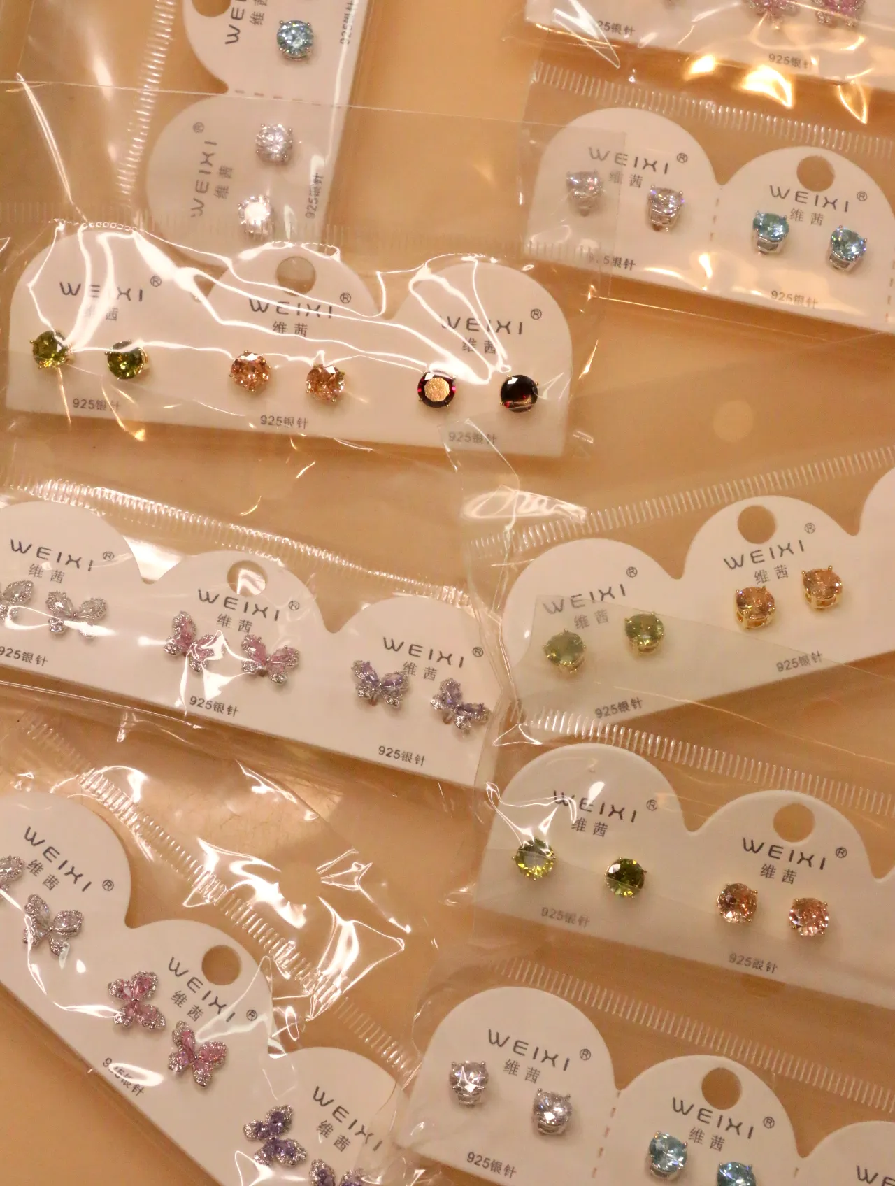 Surtido de pendientes de colores y mariposas sobre tarjetas — lote de pendientes baratos, detalle · Lola y Sol (0017)