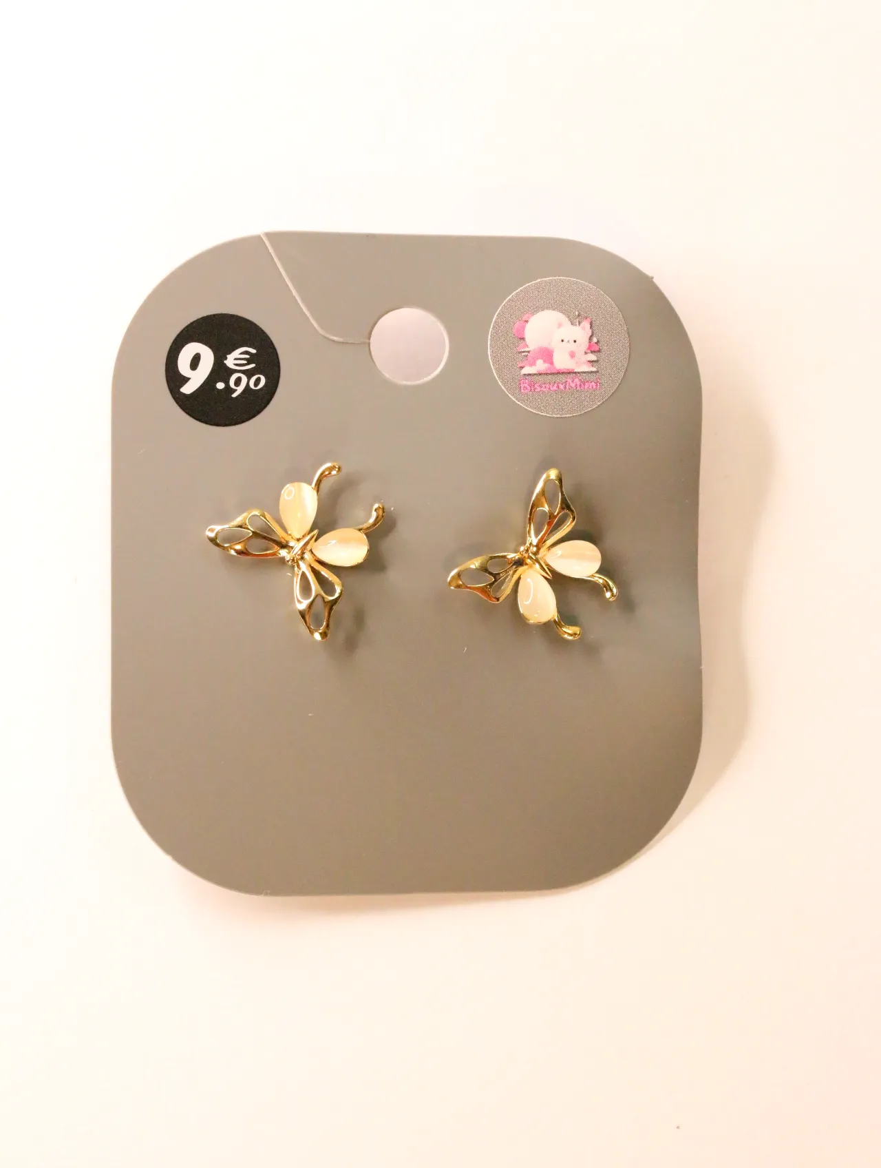 Pendientes de mariposa dorados con detalles crema sobre tarjeta — pendientes para mujer, vista principal · Lola y Sol (24AE1008)