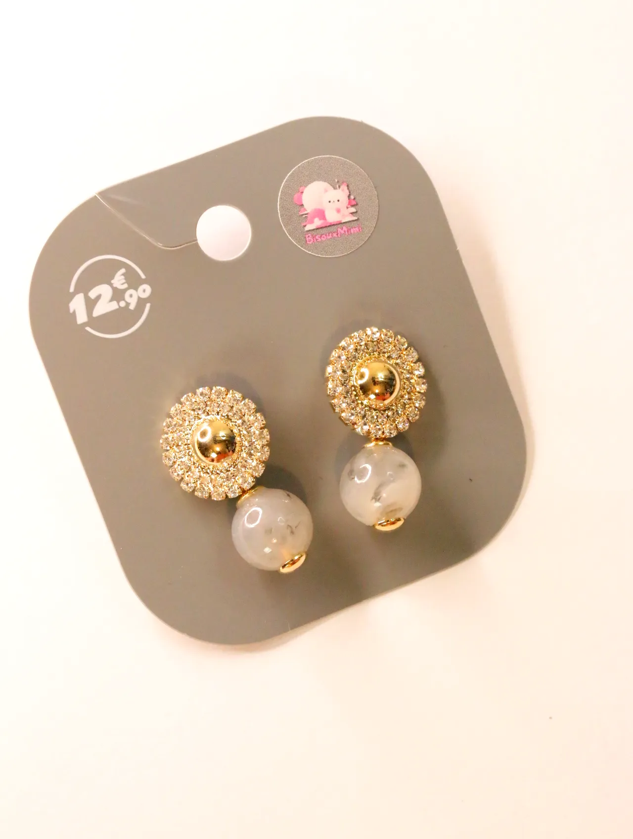 Pendientes dorados con strass y cuentas marmoleadas claras sobre tarjeta — pendientes para mujer, vista principal · Lola y Sol (24AE1024)