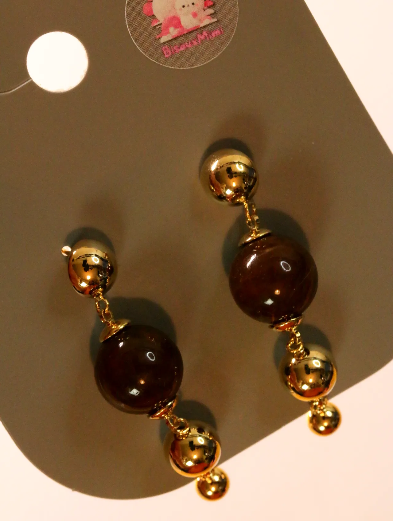 Detalle de cuentas marrones brillantes y esferas doradas — pendientes baratos, detalle · Lola y Sol (24AE1029)
