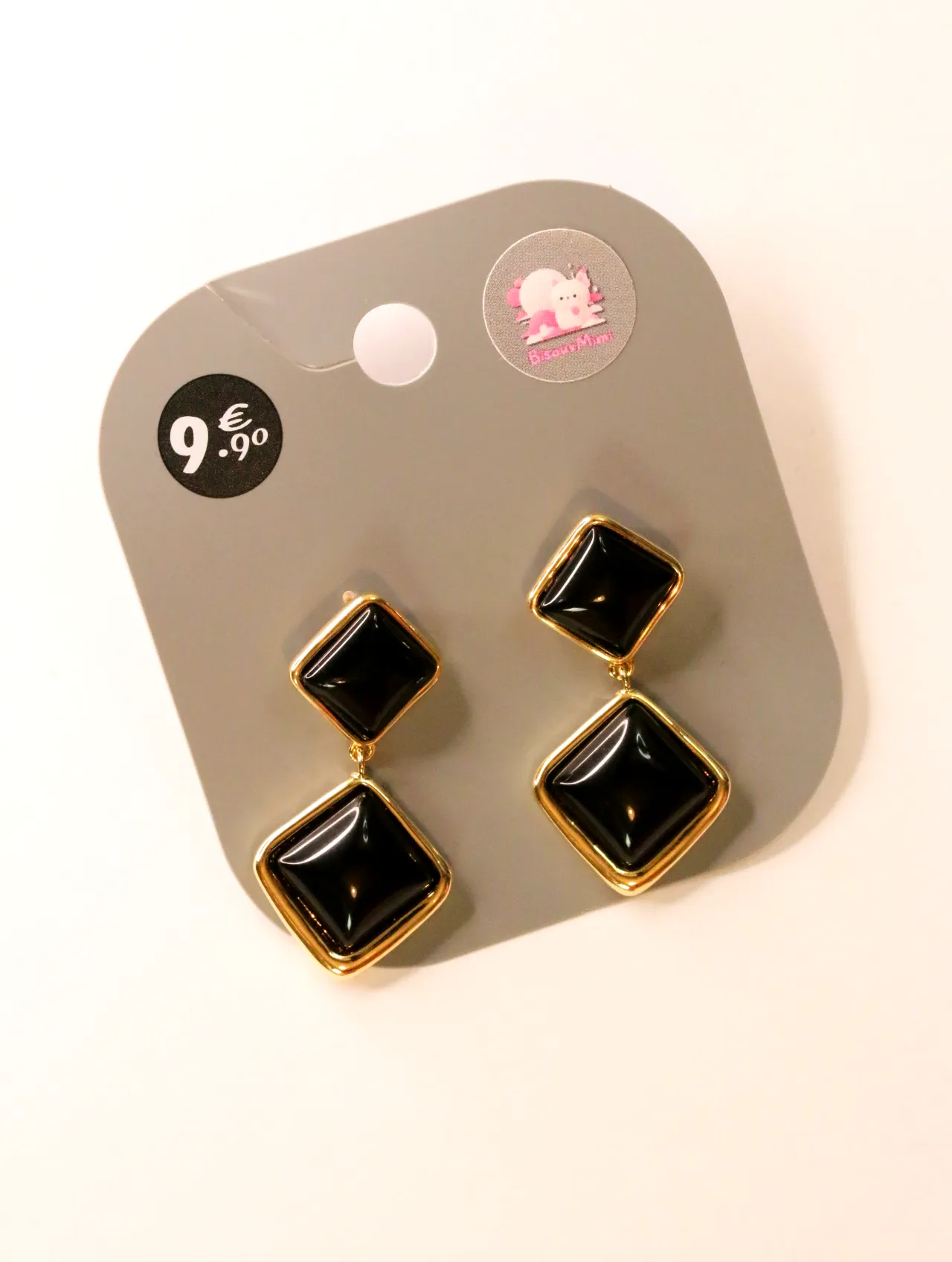 Pendientes colgantes geométricos negros con bordes dorados sobre tarjeta — pendientes para mujer, vista principal · Lola y Sol (24AE1048)