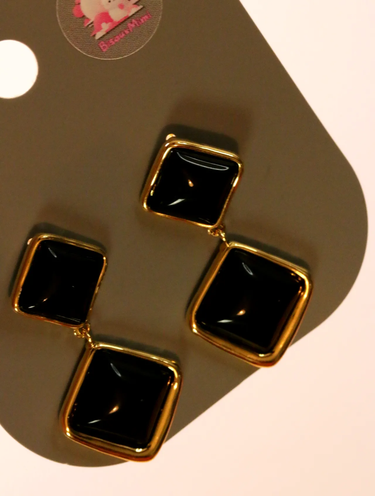 Detalle de pendientes cuadrados negros brillantes con bordes dorados — pendientes baratos, detalle · Lola y Sol (24AE1048)