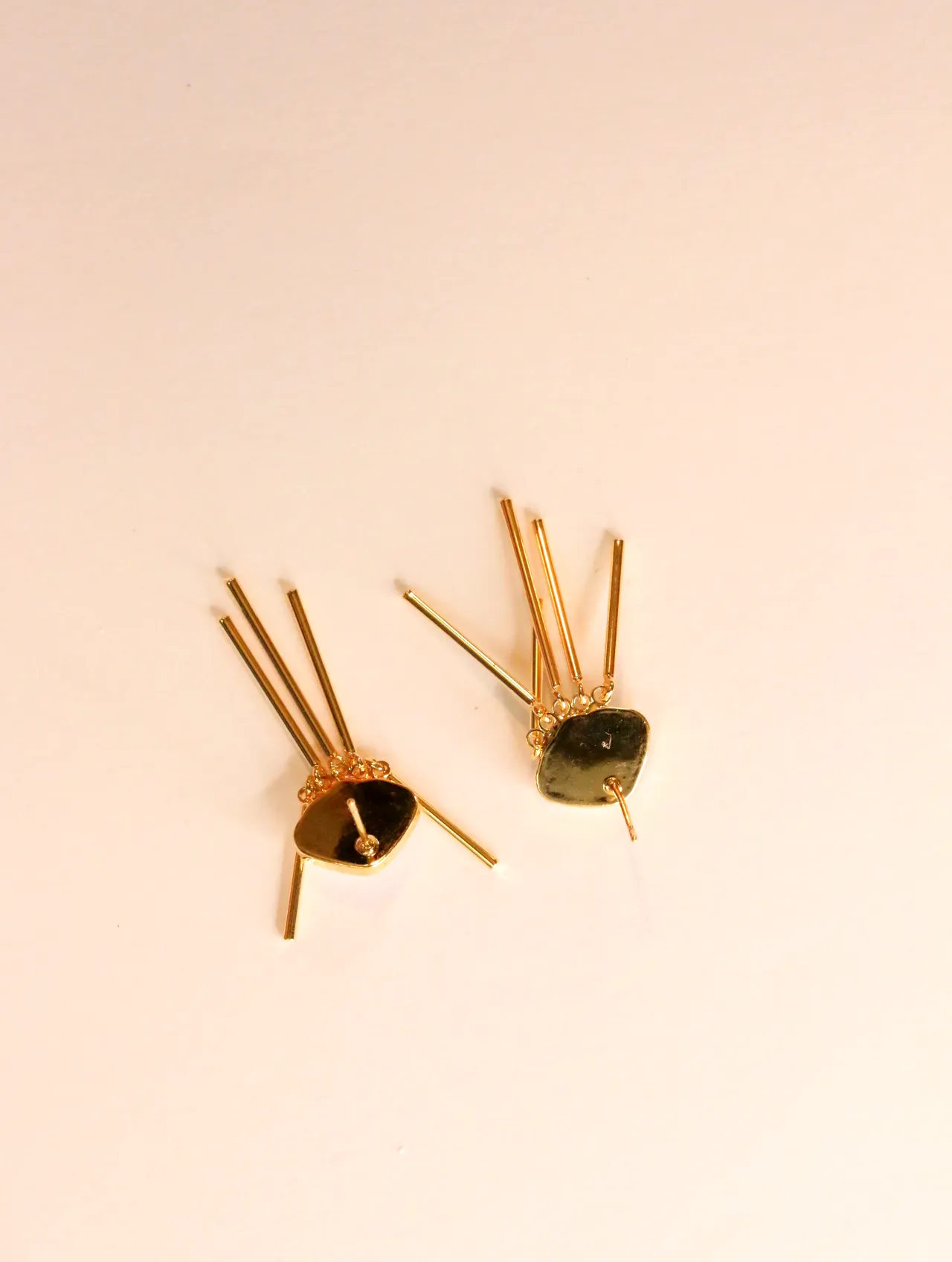 Reverso de los pendientes dorados de flecos con los pasadores visibles — pendientes dorados, primer plano · Lola y Sol (24AE1052)