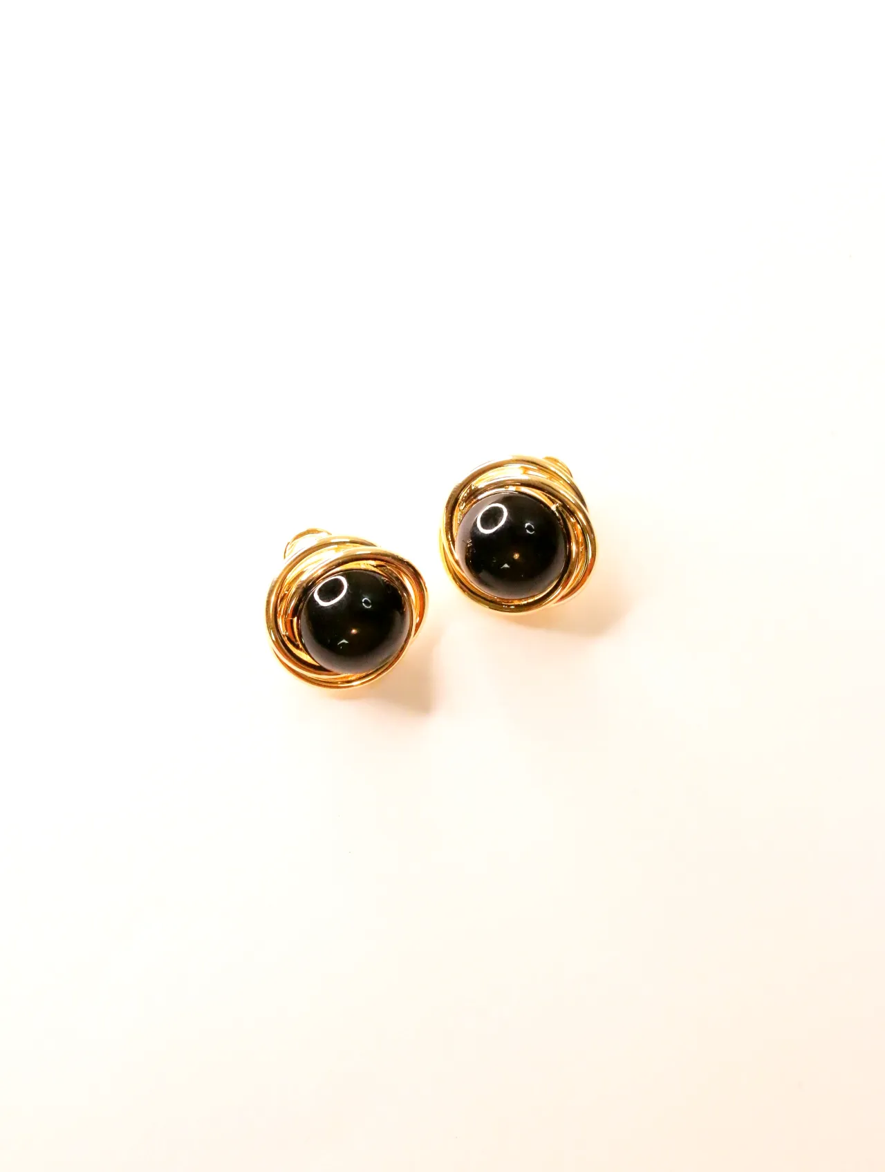 Pendientes redondeados negros y dorados sobre fondo claro — pendientes para mujer, vista principal · Lola y Sol (24AE1061)
