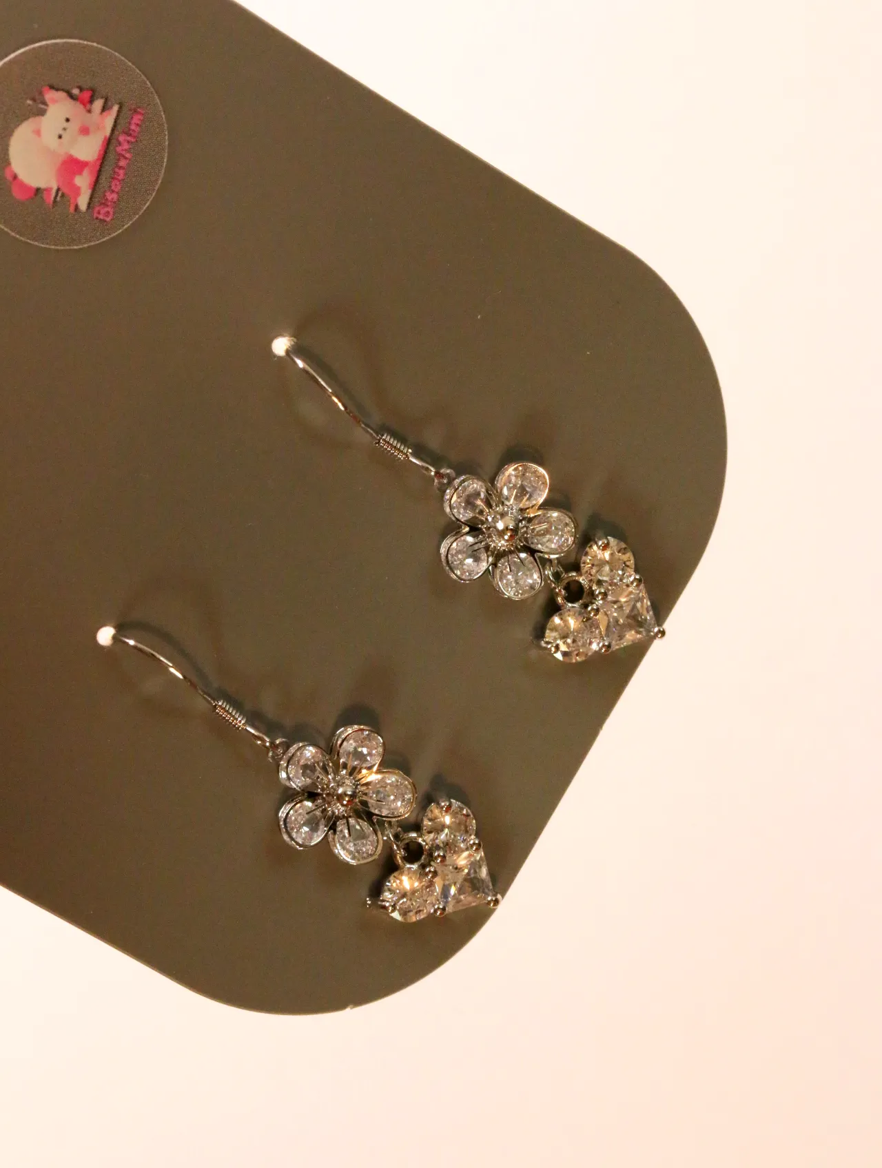 Detalle de los pendientes brillantes con flor y corazón — pendientes baratos, detalle · Lola y Sol (24AE1203)