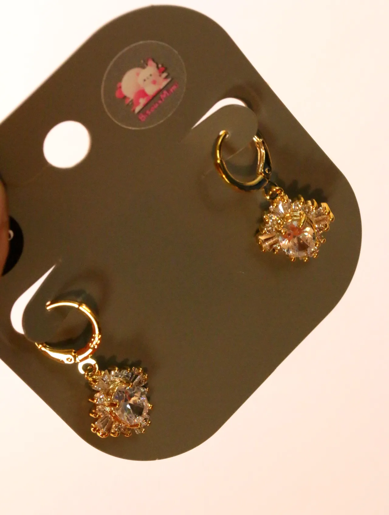 Detalle de los aros dorados y las piedras decorativas transparentes — pendientes baratos, detalle · Lola y Sol (24AE1216)