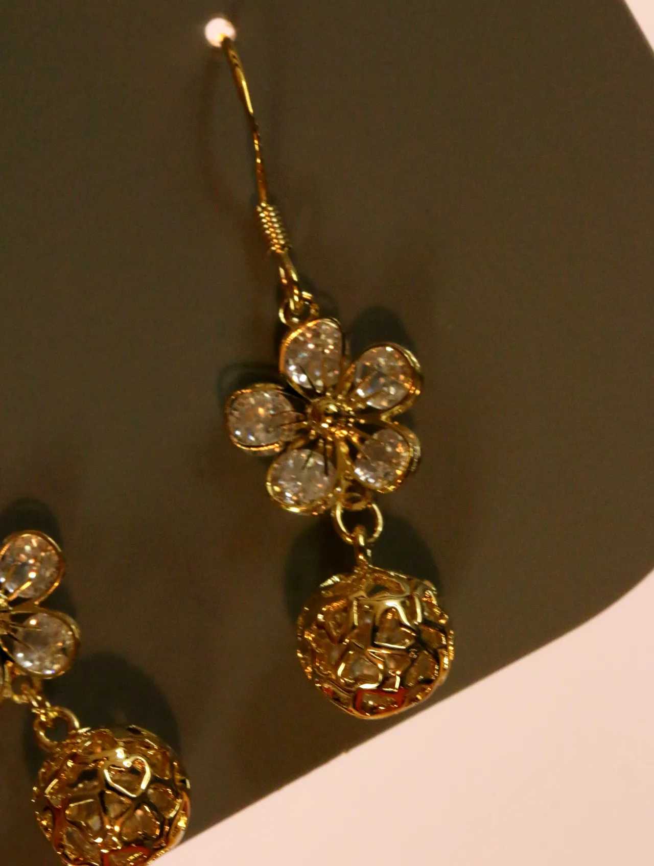 Detalle de la flor brillante y la bola calada dorada — pendientes baratos, detalle · Lola y Sol (24AE1230)