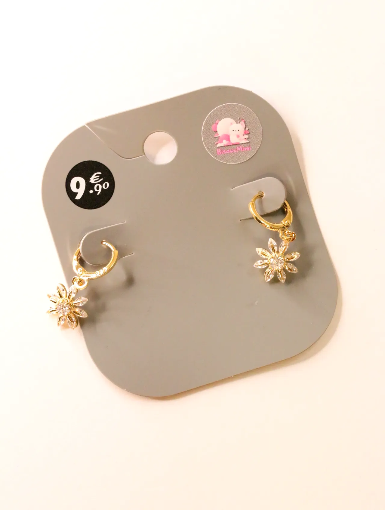 Pendientes de aro dorados con flores colgantes sobre tarjeta — pendientes para mujer, vista principal · Lola y Sol (24AE1240)