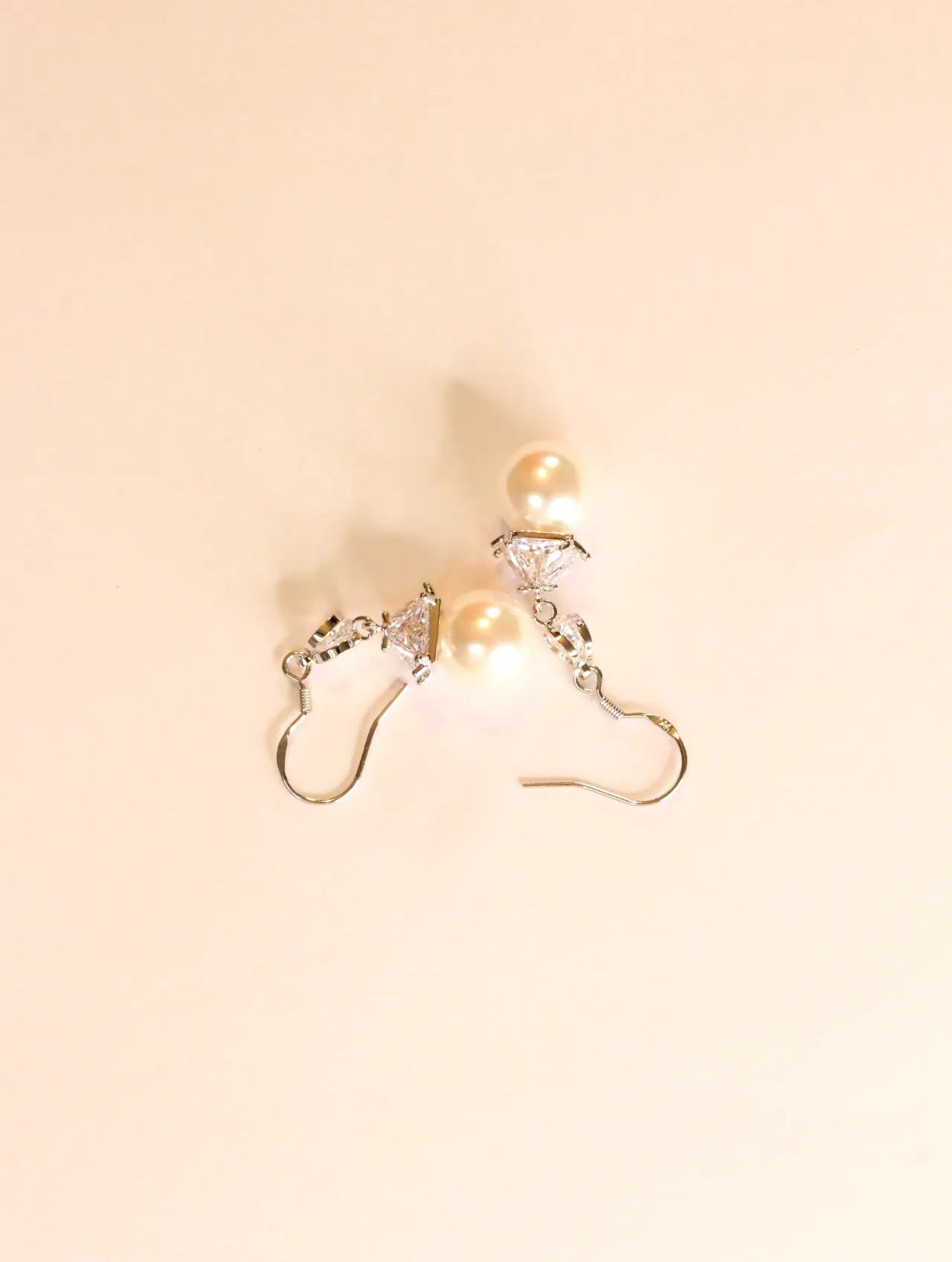 Vista lateral de pendientes con perlas de imitación y cierres de gancho — pendientes originales, detalle del acabado · Lola y Sol (24AE1247)