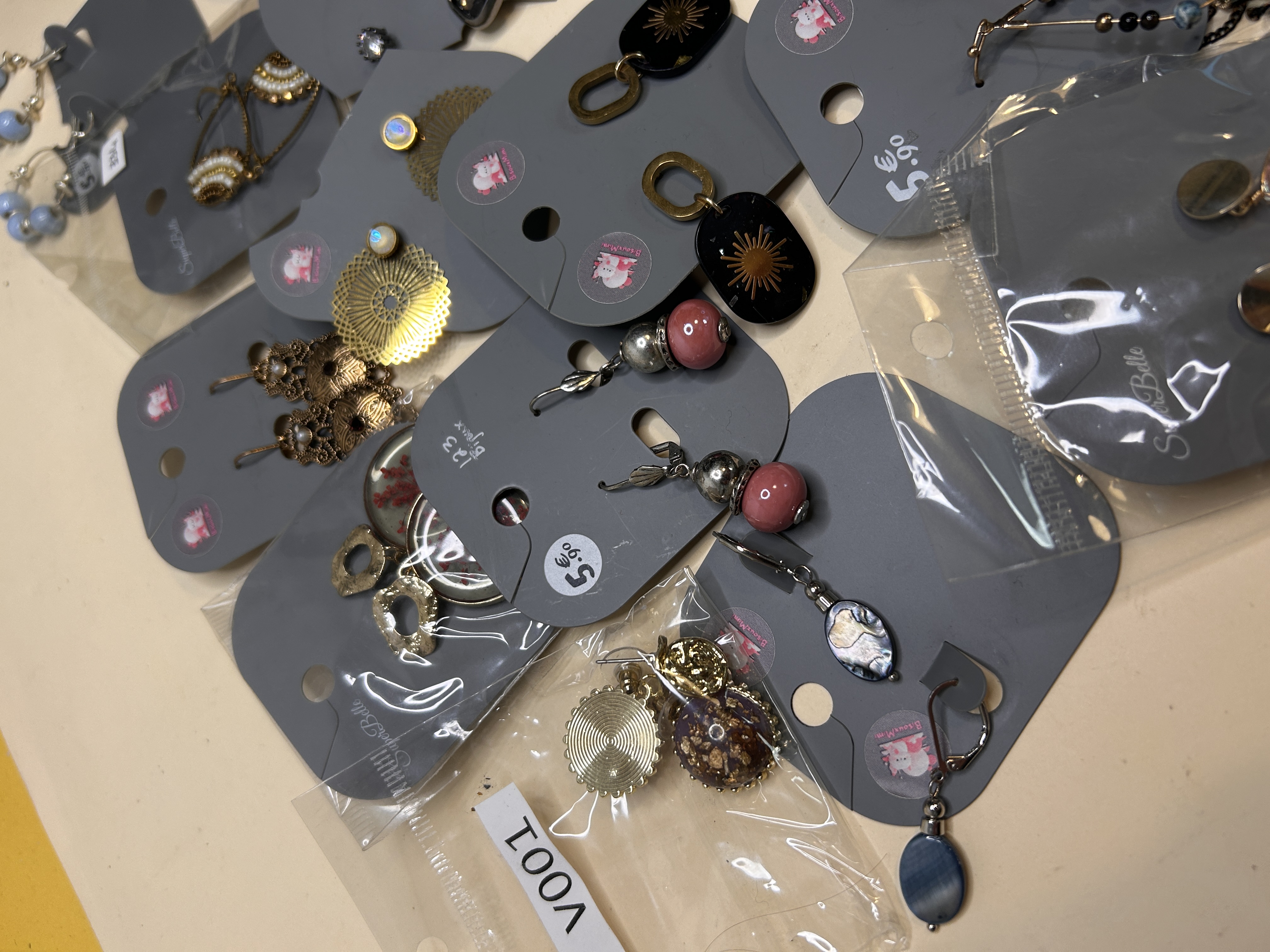 Detalle de pendientes surtidos con elementos metálicos y cuentas — lote de pendientes de moda, vista lateral · Lola y Sol (BO-305)