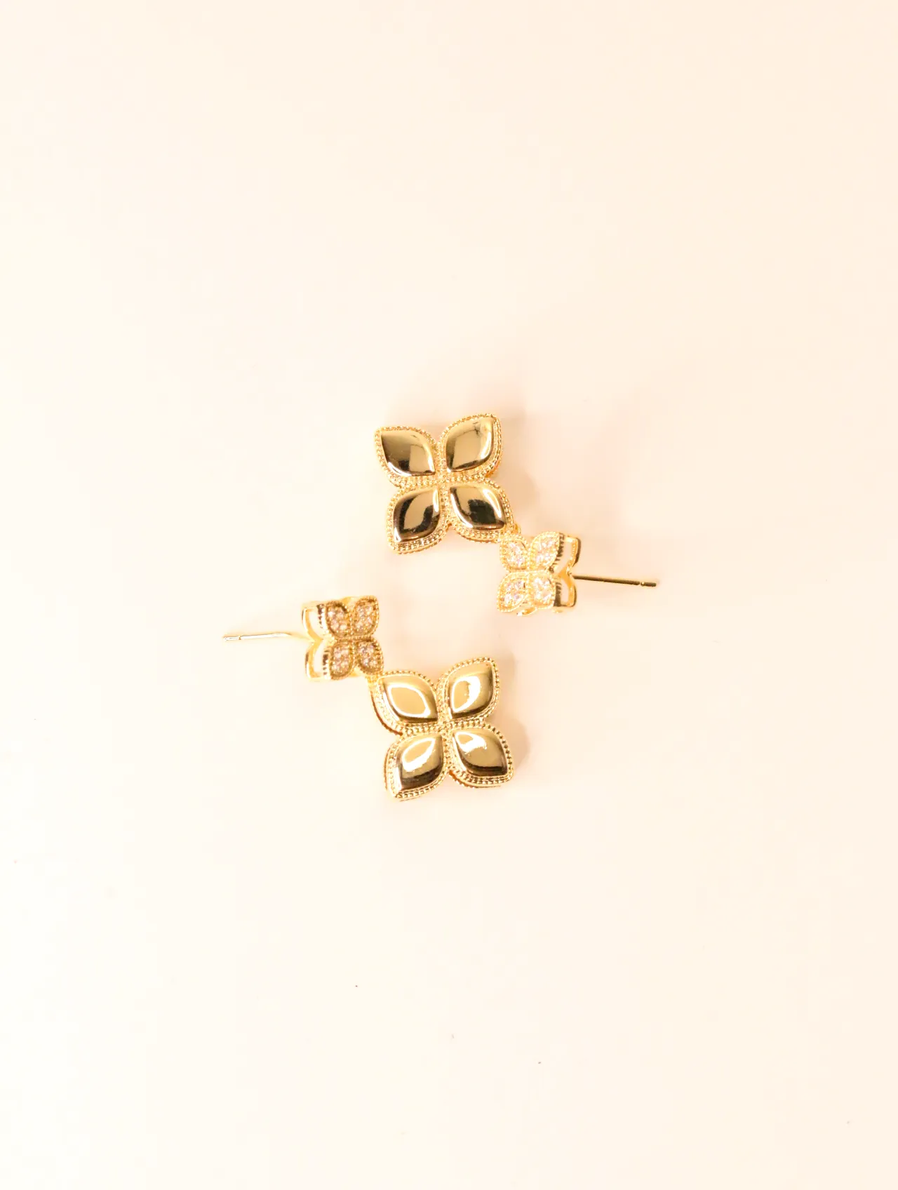 Vista superior de un par de pendientes colgantes de trébol dorados con detalles brillantes. — pendientes baratos, detalle · Lola y Sol (BO-PD-022)