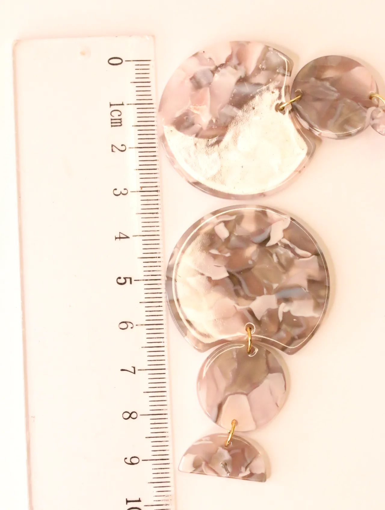 Pendiente colgante efecto mármol junto a una regla para escala — pendientes de moda, vista lateral · Lola y Sol (BO-PD-035)