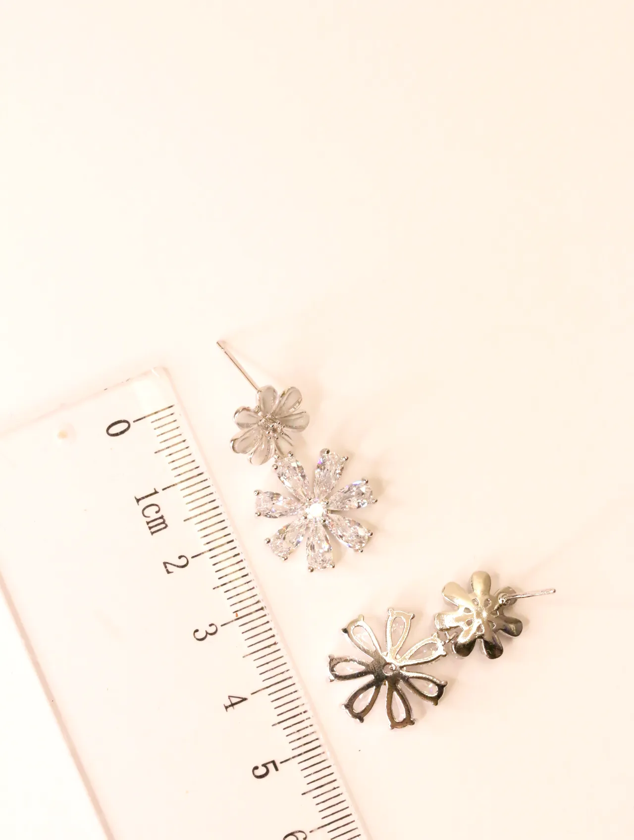 Pendientes colgantes de flor con circonitas junto a una regla, mostrando el tamaño — pendientes baratos, detalle · Lola y Sol (BO-PD-036)