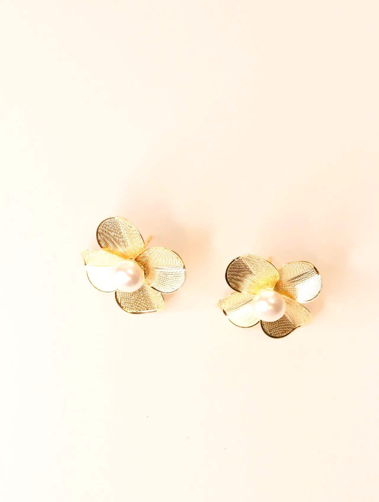 Par de pendientes de flor dorada con perlas sobre fondo claro — pendientes dorados, primer plano · Lola y Sol (BO-PD-039)