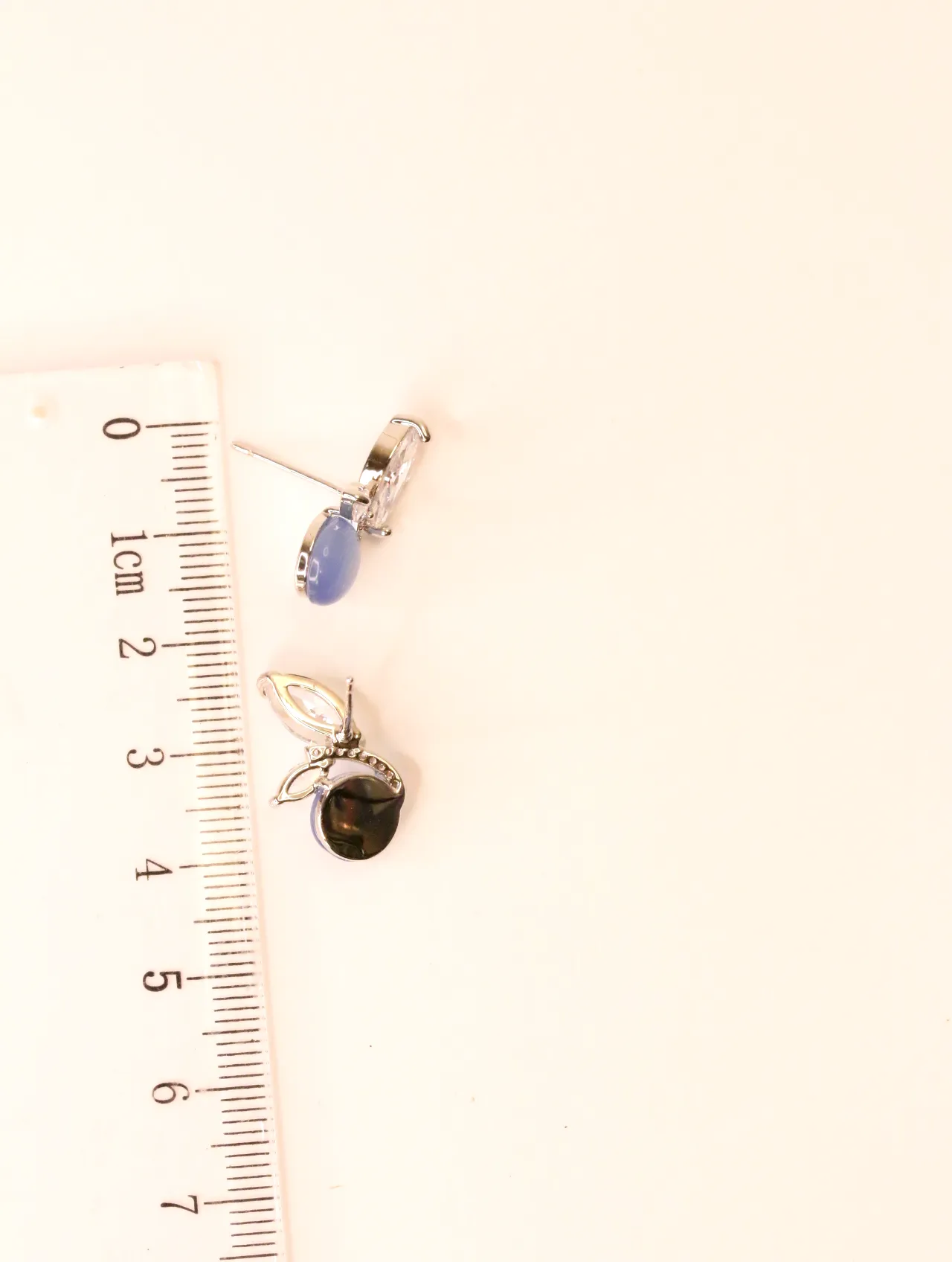 Par de pendientes con piedra azul y circonitas, junto a una regla para escala, mostrando las dimensiones — pendientes de moda, vista lateral · Lola y So…