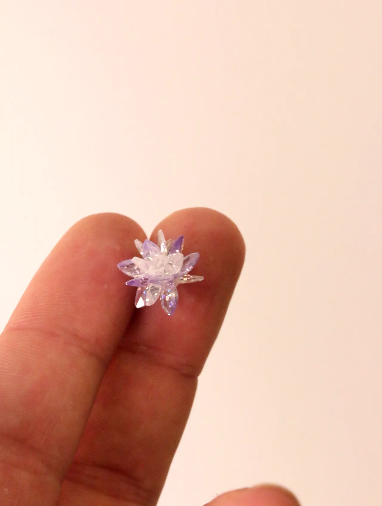 Primer plano de un pendiente de estrella brillante sostenido entre los dedos — pendientes dorados, primer plano · Lola y Sol (BO-PD-46)