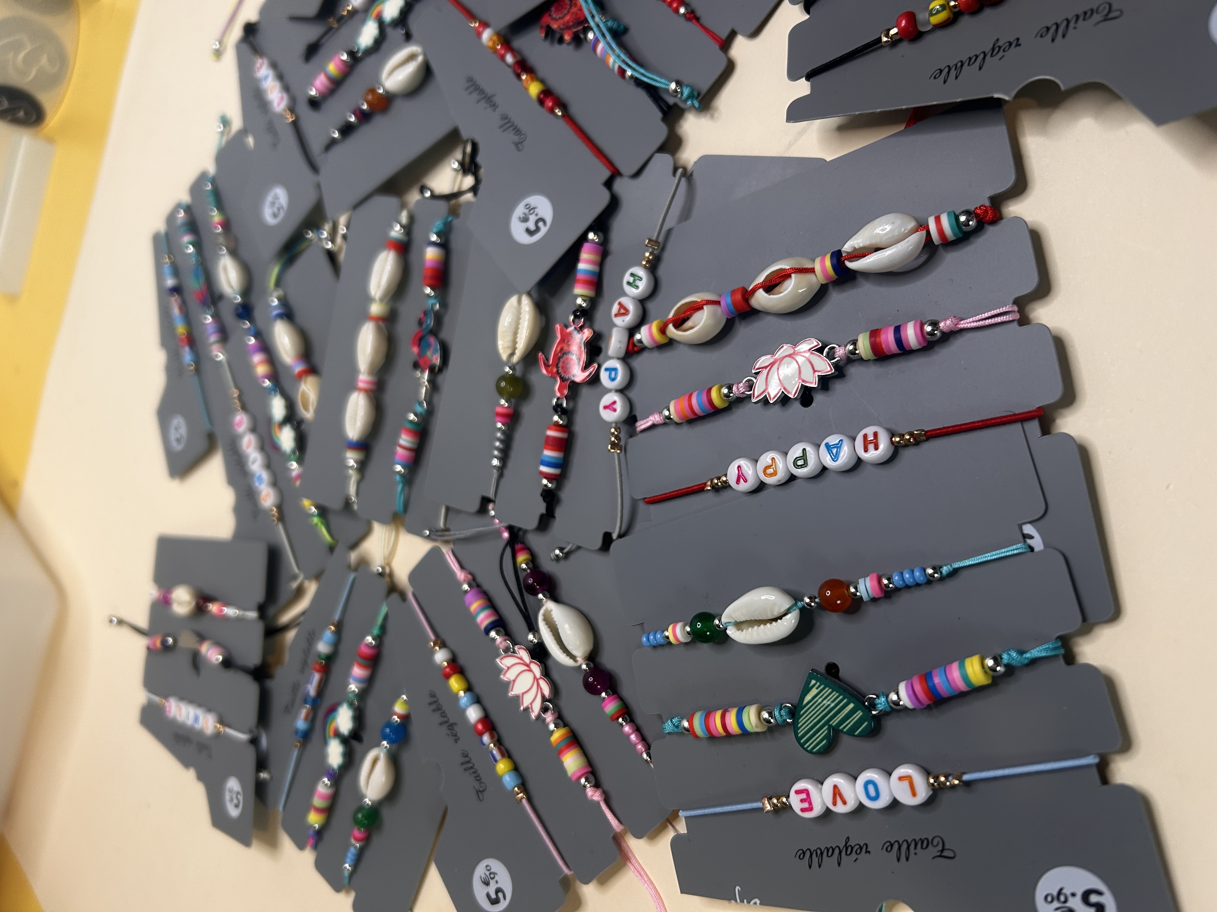 Surtido de pulseras de cordón veraniegas con letras y motivos decorativos — lote de pendientes de moda, vista lateral · Lola y Sol (BRC-CRD-86)