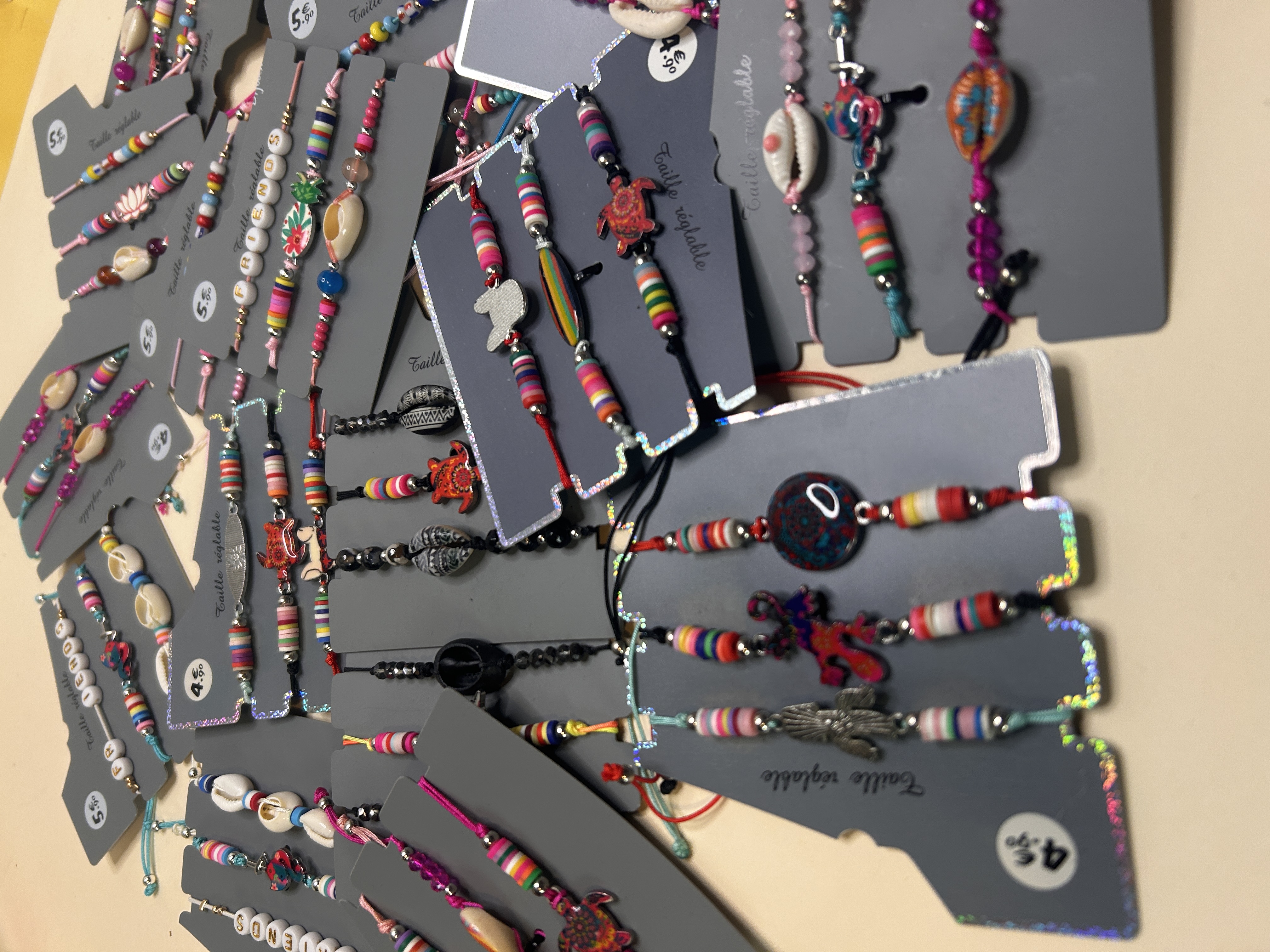 Surtido de pulseras ajustables multicolor con conchas y dijes — lote de pendientes originales, detalle del acabado · Lola y Sol (BRC-CRD-88)