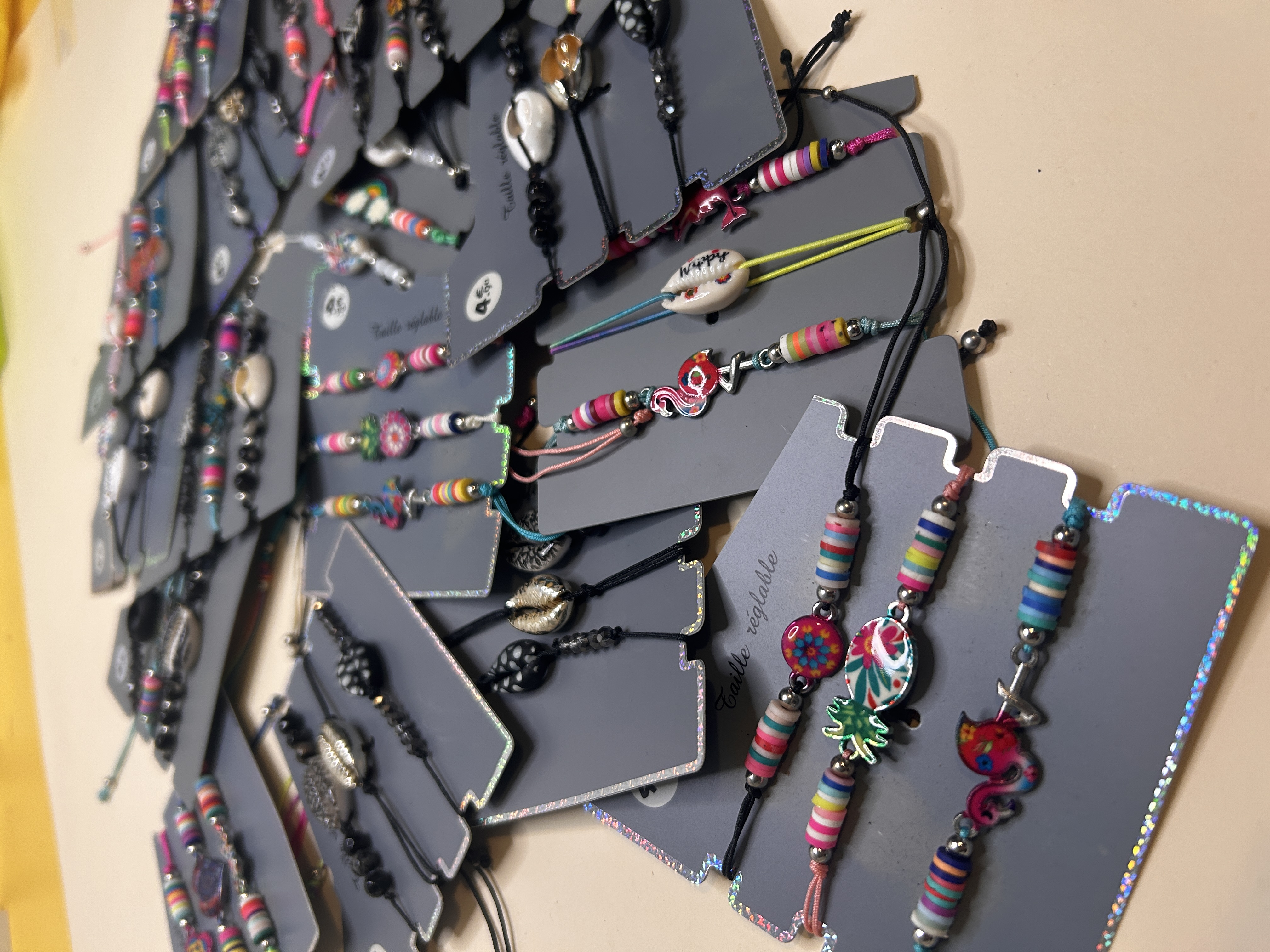 Primer plano de pulseras con dijes de flamenco, piña y conchas — lote de pendientes dorados, primer plano · Lola y Sol (BRC-CRD-89)