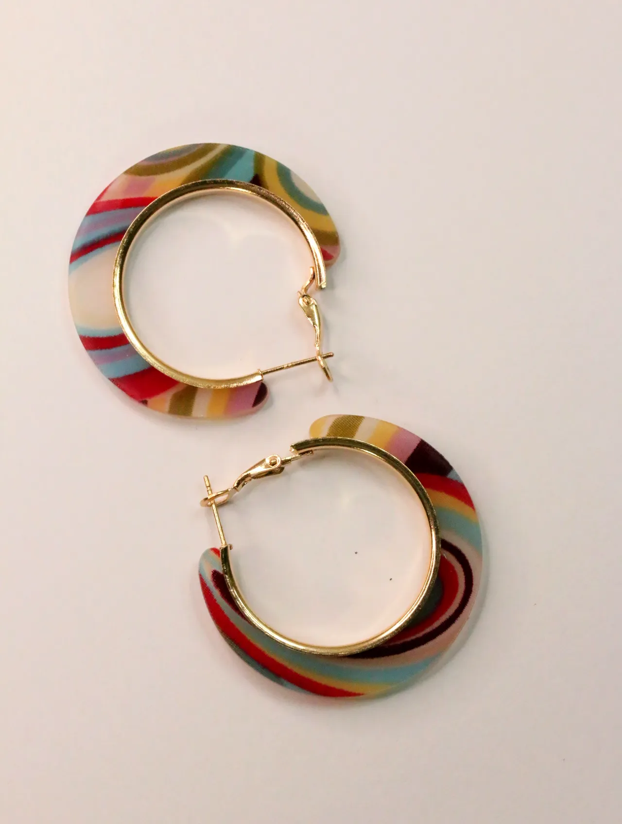 Pendientes de aro multicolor con bordes dorados sobre fondo claro — pendientes dorados, primer plano · Lola y Sol (CLR-HPS-002)
