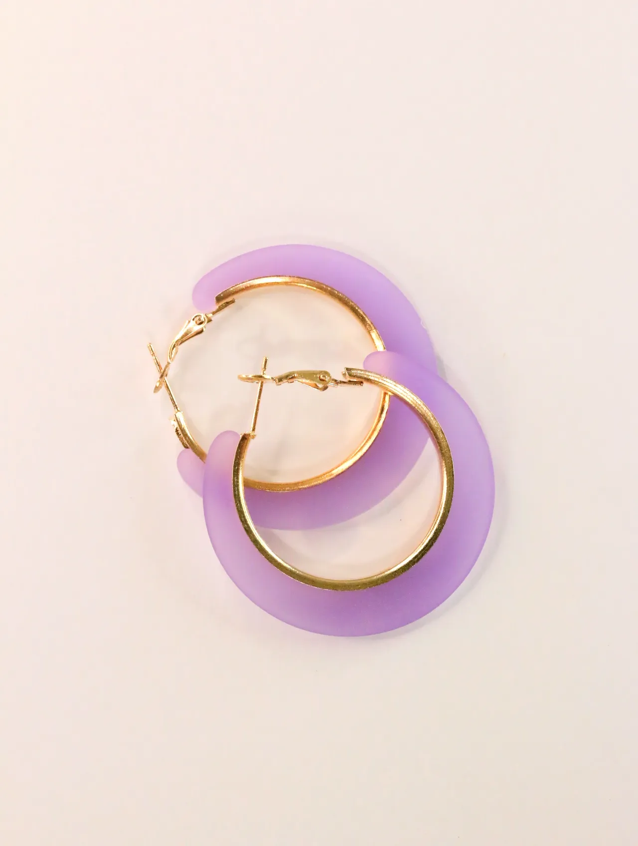 Pendientes de aro lilas superpuestos con cierres dorados visibles — pendientes dorados, primer plano · Lola y Sol (CLR-HPS-004)