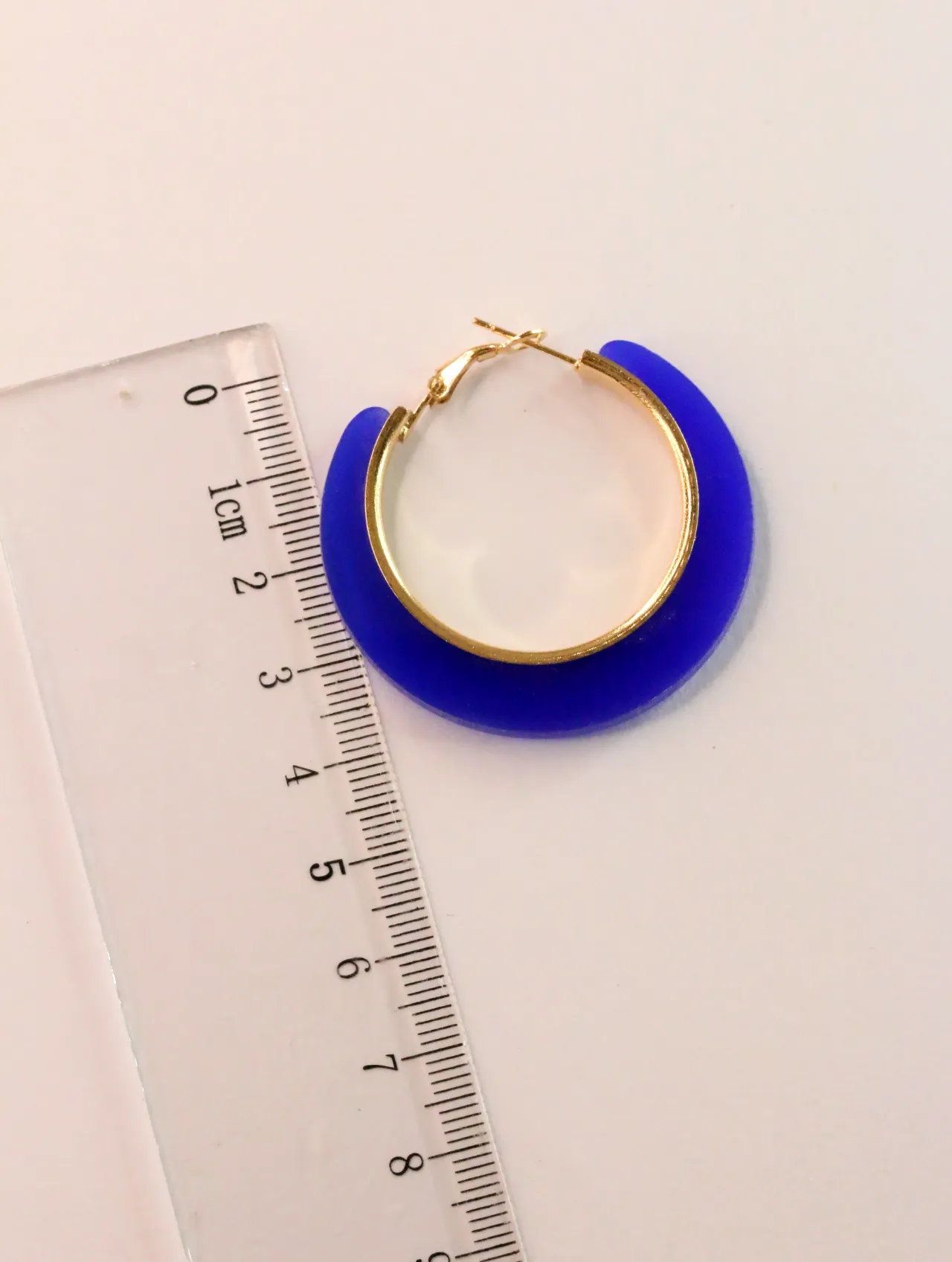 Pendiente de aro azul junto a una regla — pendientes baratos, detalle · Lola y Sol (CLR-HPS-008)