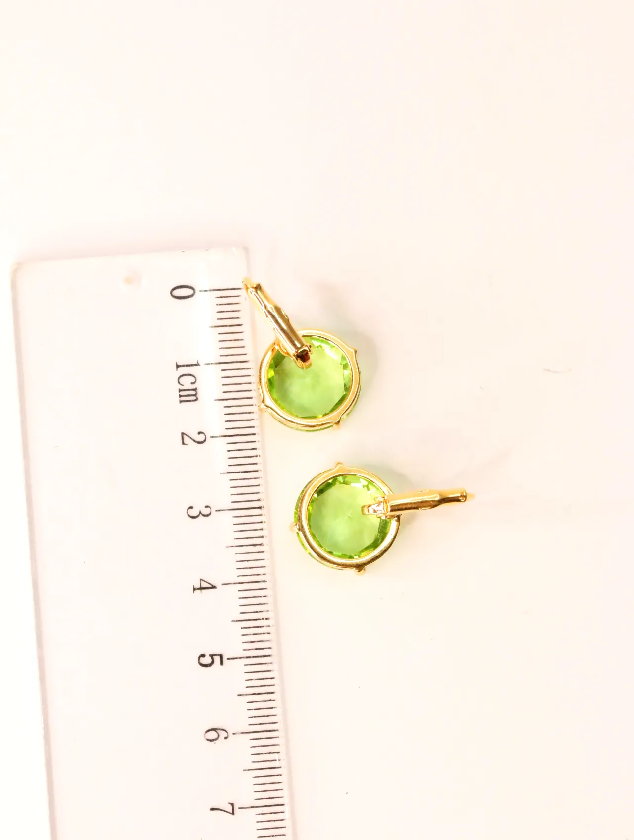 Pendientes largos de piedra verde junto a una regla para referencia de tamaño — pendientes de moda, vista lateral · Lola y Sol (EAR-008)