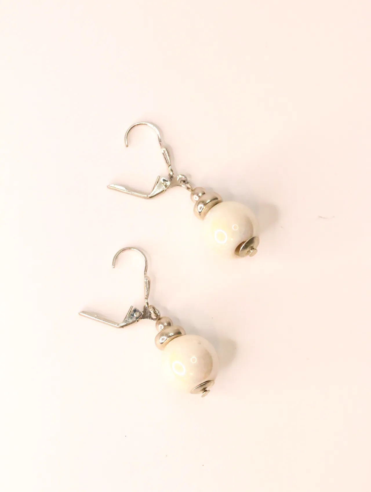 Par de pendientes largos elegantes con cuentas de cerámica y fornituras tono plata sobre fondo blanco — pendientes para mujer, vista principal · Lola y…