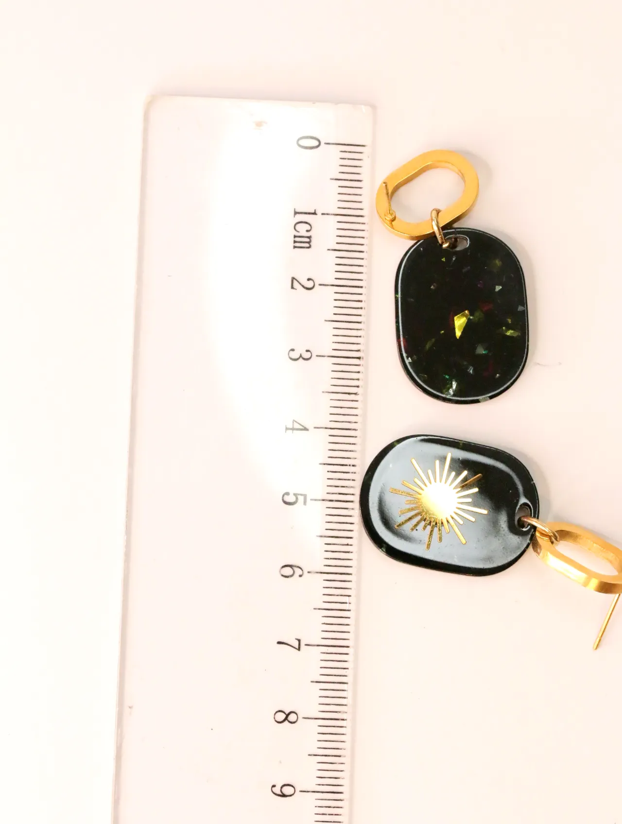 Pendientes largos mostrando el tamaño junto a una regla — pendientes dorados, primer plano · Lola y Sol (EAR-011)