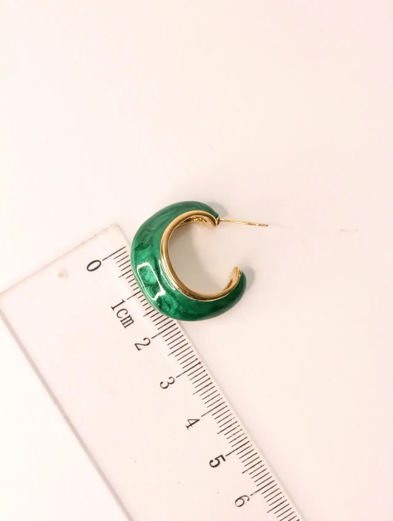 Pendiente de aro esmaltado en verde junto a una regla de medir — pendientes de moda, vista lateral · Lola y Sol (EAR-014)