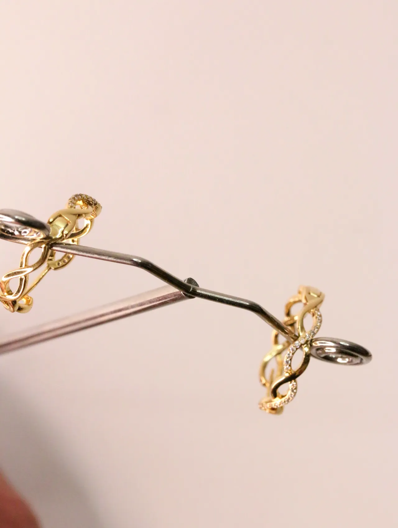 Detalle de los pendientes de aro dorados con pedrería en soporte expositor — pendientes originales, detalle del acabado · Lola y Sol (EAR-016)