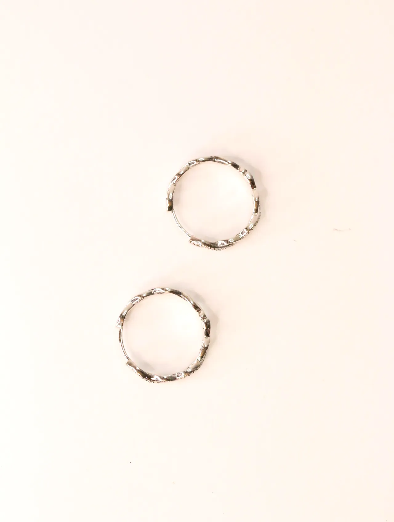 Pendientes de aro plateados con textura cerrados sobre fondo blanco — pendientes dorados, primer plano · Lola y Sol (EAR-017)