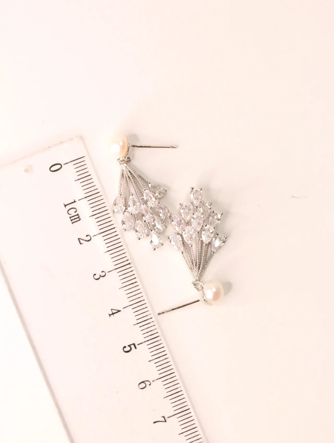 Pendientes de cristales y perlas mostrados junto a una regla — pendientes de moda, vista lateral · Lola y Sol (EAR-019)