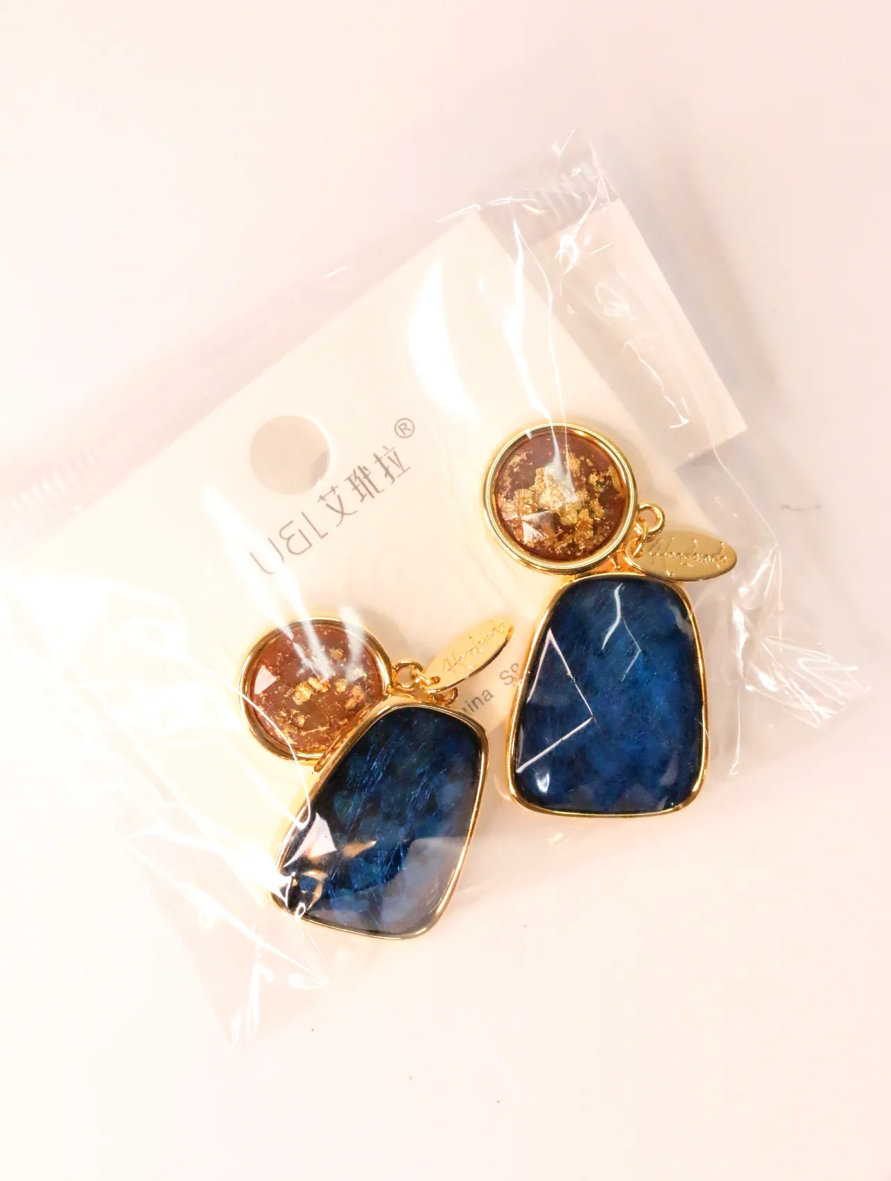 Pendientes colgantes en azul y ámbar dentro de bolsita transparente — pendientes para mujer, vista principal · Lola y Sol (EAR-024)