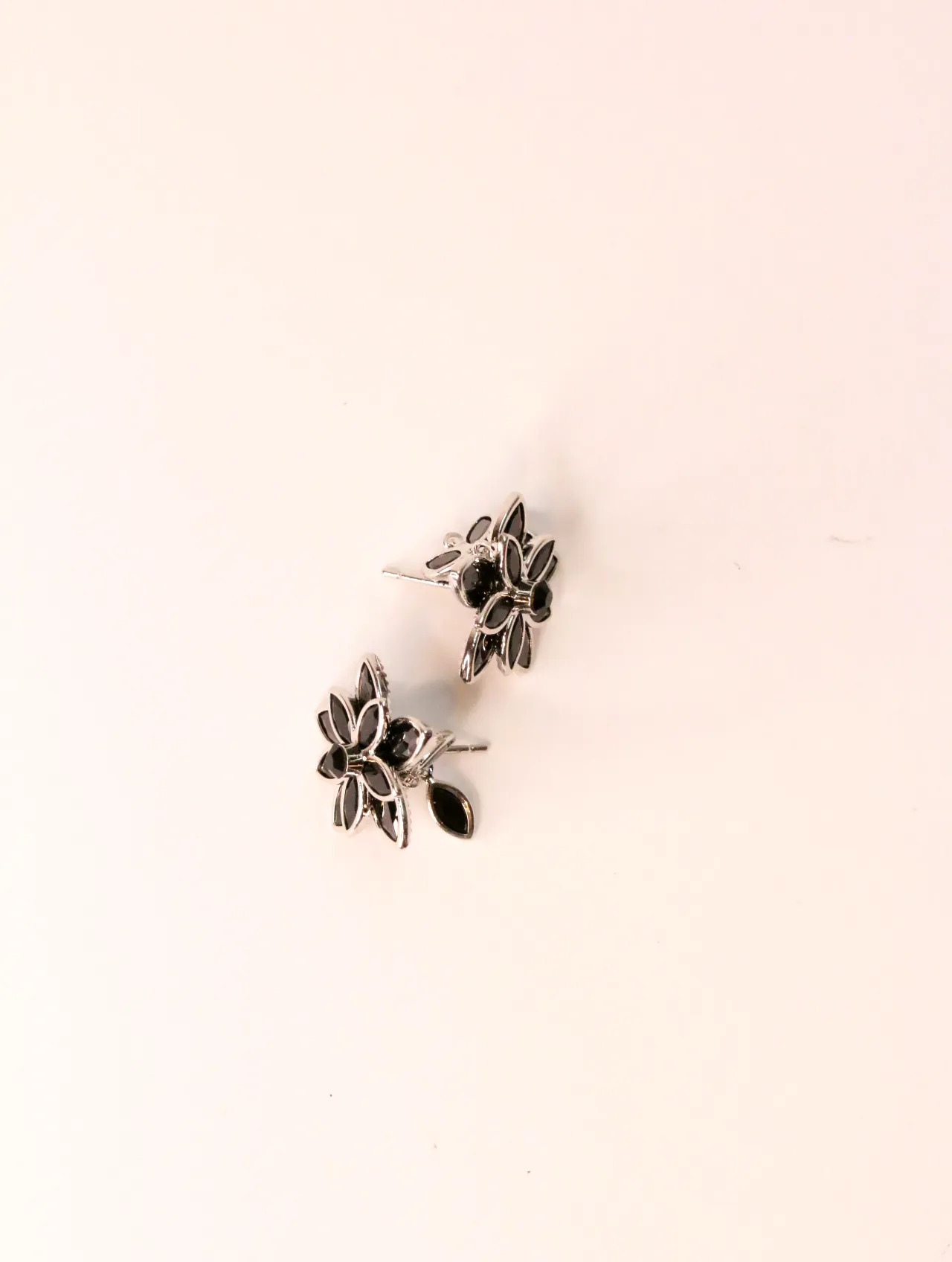 Par de pendientes florales negros en ángulo sobre fondo liso — pendientes para mujer, vista principal · Lola y Sol (EAR-025)