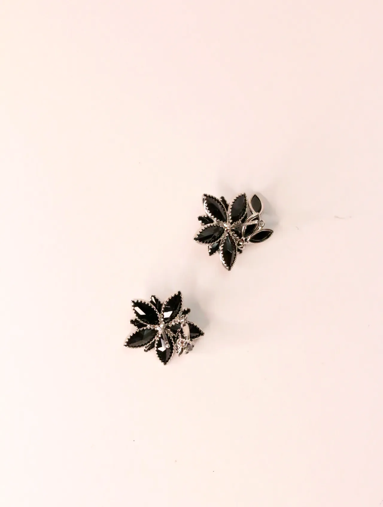 Vista superior del par de pendientes con forma de flor negra y borde plateado — pendientes baratos, detalle · Lola y Sol (EAR-025)