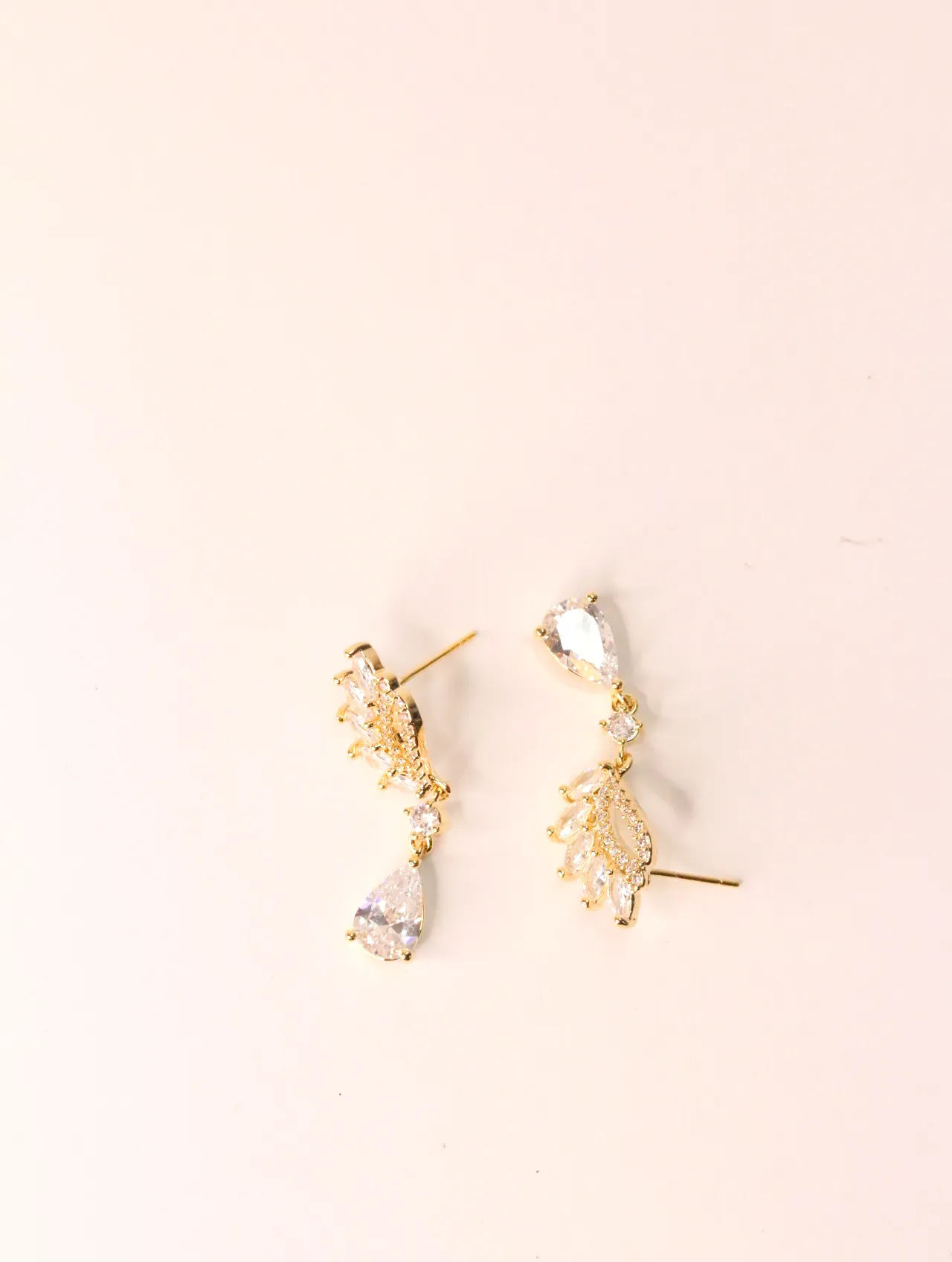 Pendientes dorados con circonitas y colgante en forma de lágrima sobre fondo rosa claro — pendientes para mujer, vista principal · Lola y Sol (EAR-030)