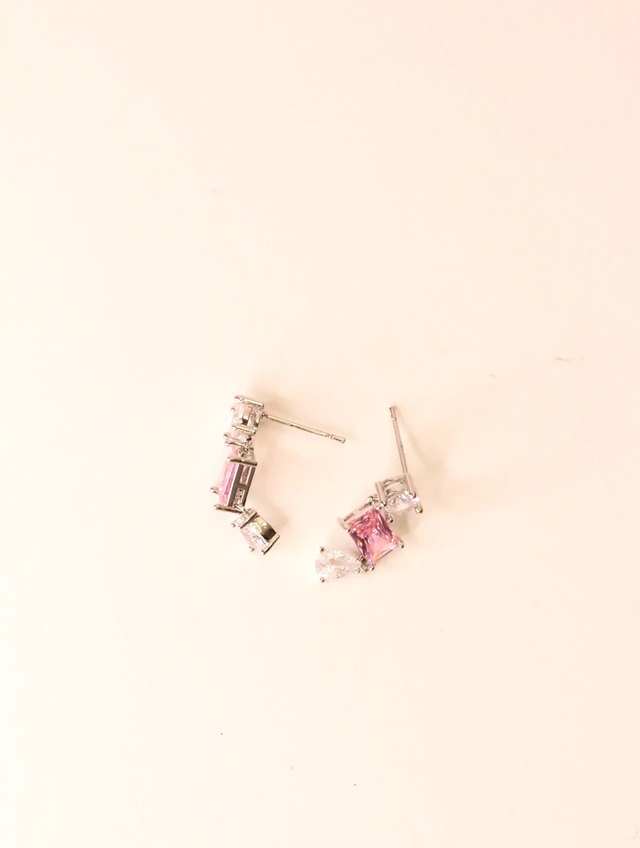 Pareja de pendientes plateados con piedras rosas sobre fondo blanco — pendientes originales, detalle del acabado · Lola y Sol (EAR-046)