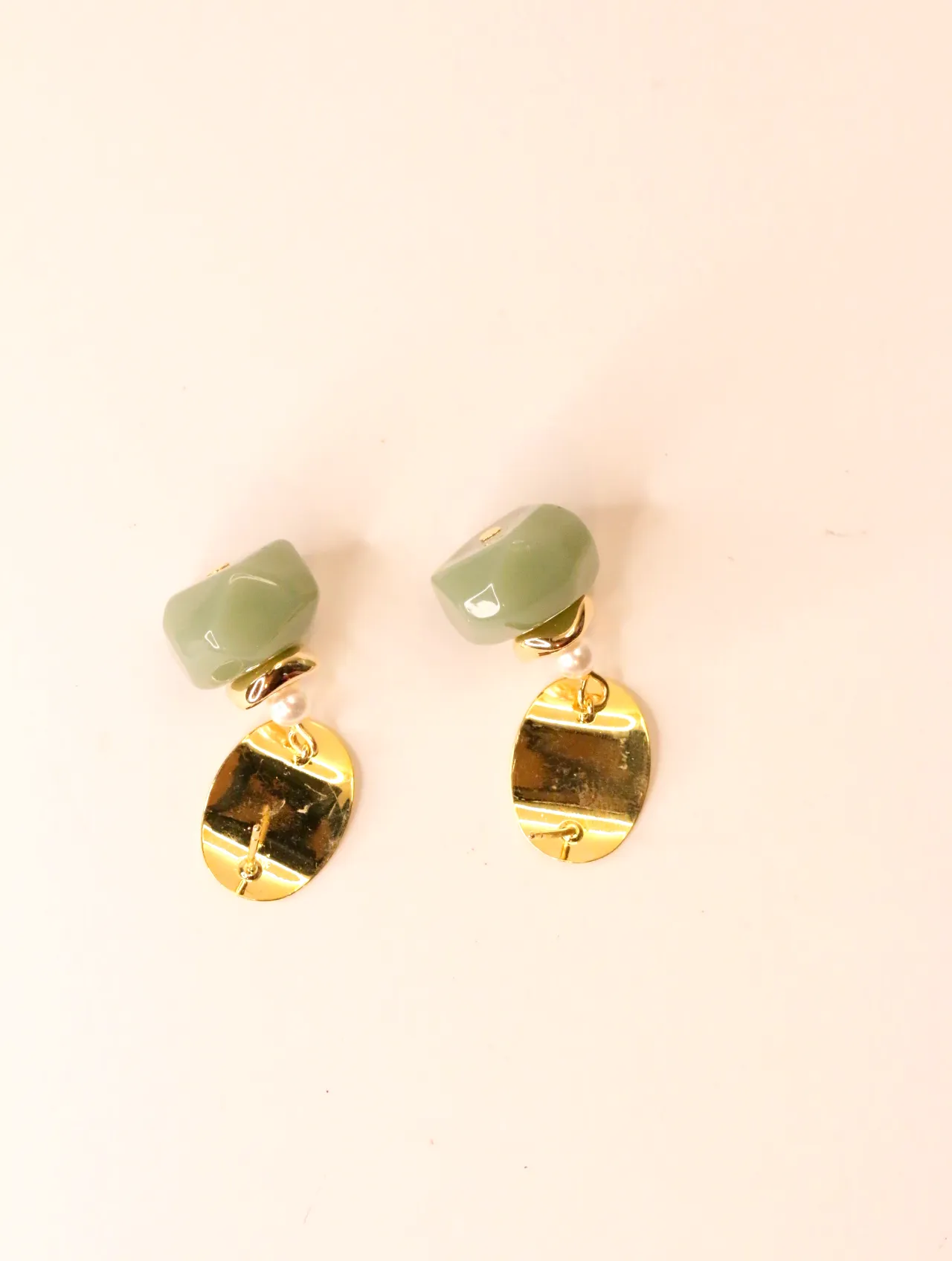 Pendientes dorados con cuentas verdes colocados sobre superficie lisa — pendientes baratos, detalle · Lola y Sol (EAR-050)