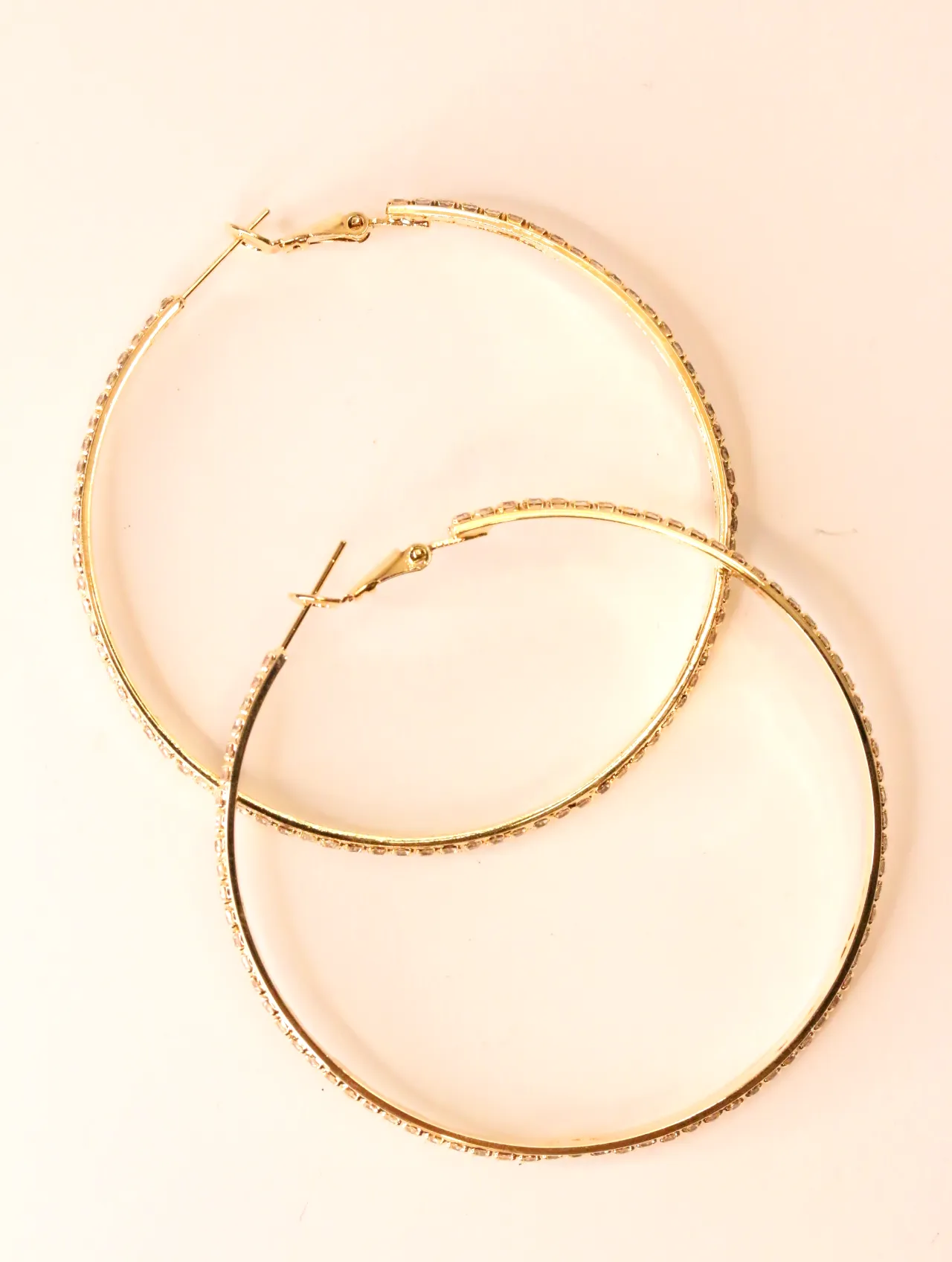 Pendientes de aro dorados con incrustaciones de strass sobre fondo neutro — pendientes para mujer, vista principal · Lola y Sol (EAR-051)