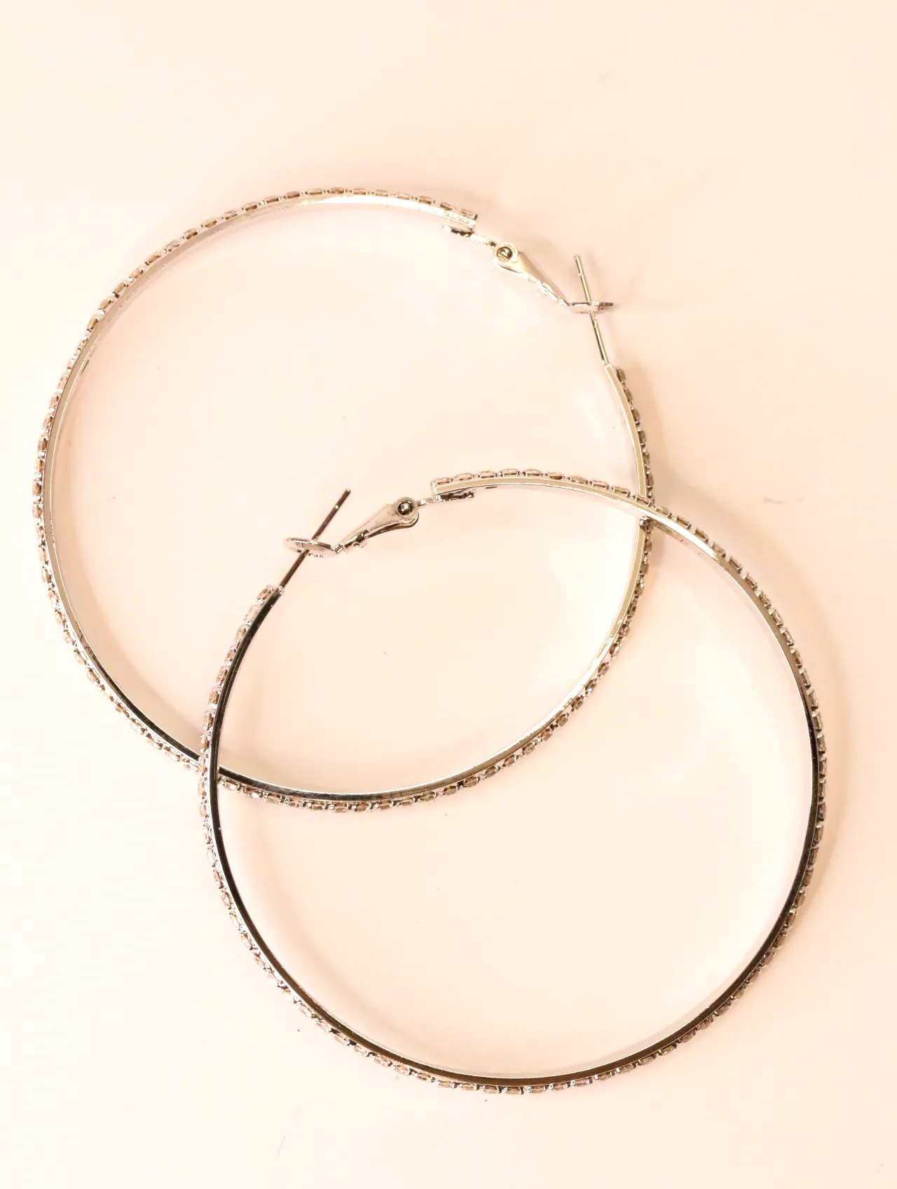 Pareja de pendientes de aro plateados con pedrería de strass — pendientes baratos, detalle · Lola y Sol (EAR-052)