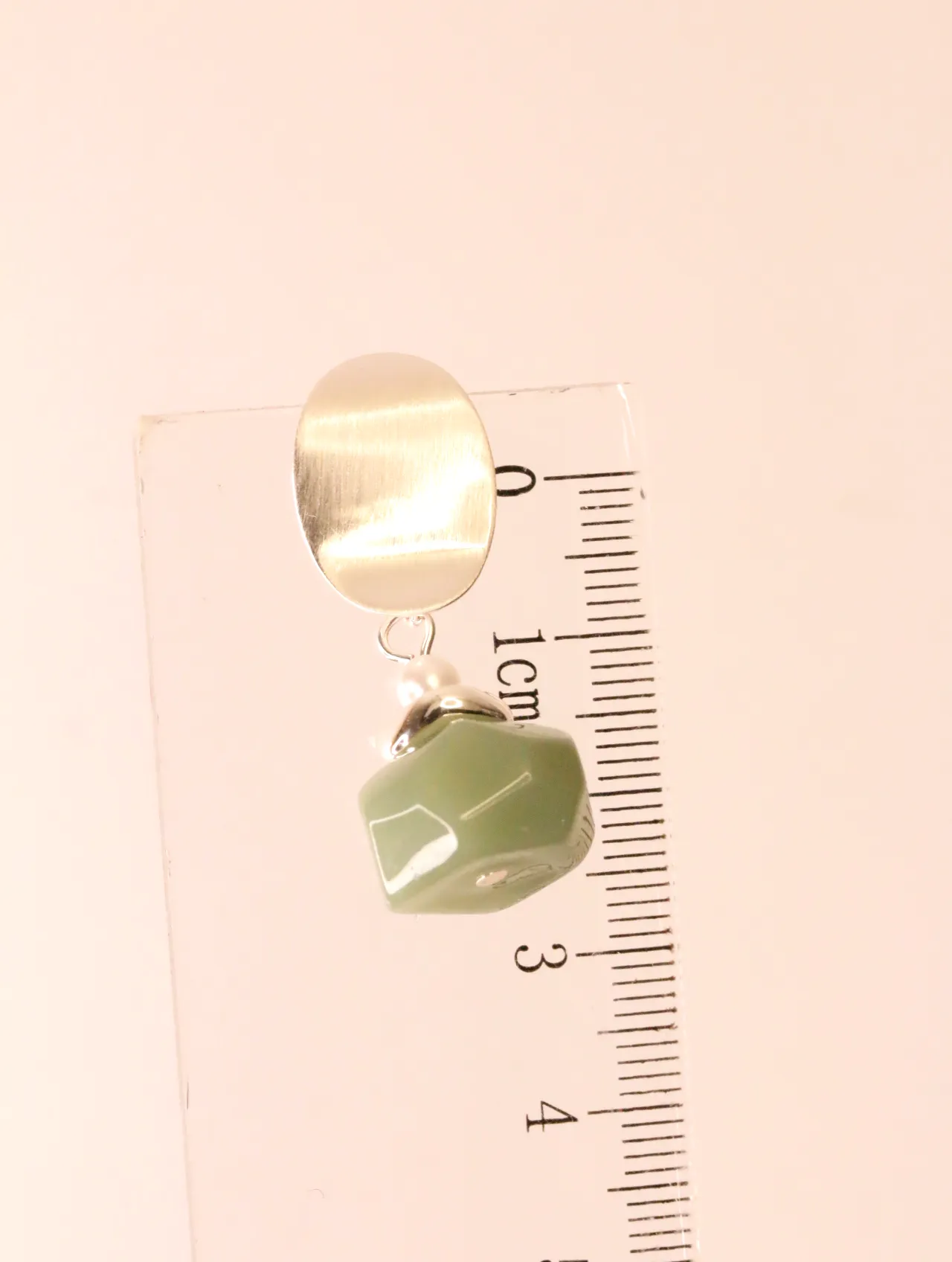 Pendiente colgante junto a una regla milimetrada para mostrar dimensiones — pendientes dorados, primer plano · Lola y Sol (EAR-054)