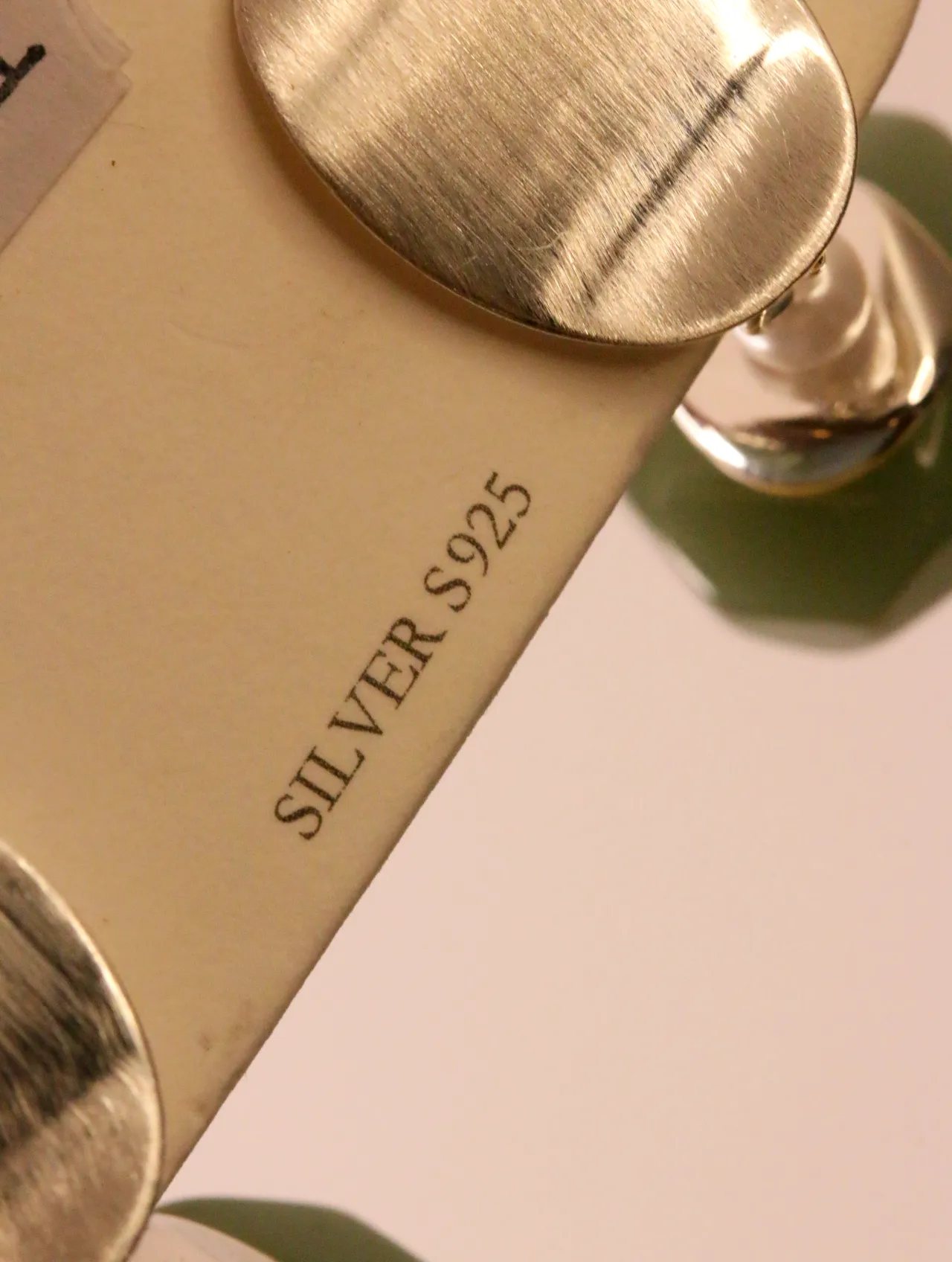 Detalle en primer plano del pendiente y la etiqueta con indicación Silver S925 — pendientes de moda, vista lateral · Lola y Sol (EAR-054)
