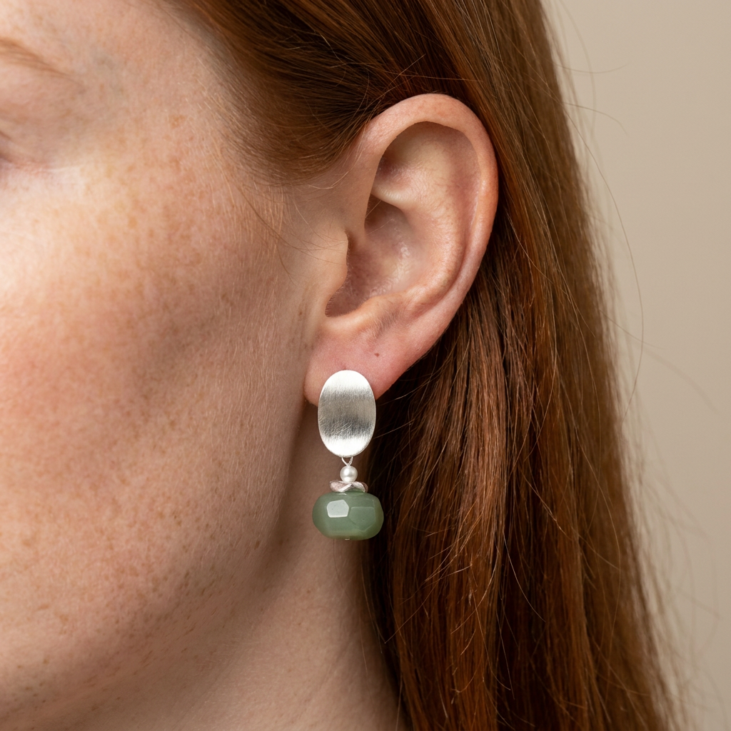 Pendientes colgantes en plata satinada con piedra verde (EAR-054) puestos en la oreja