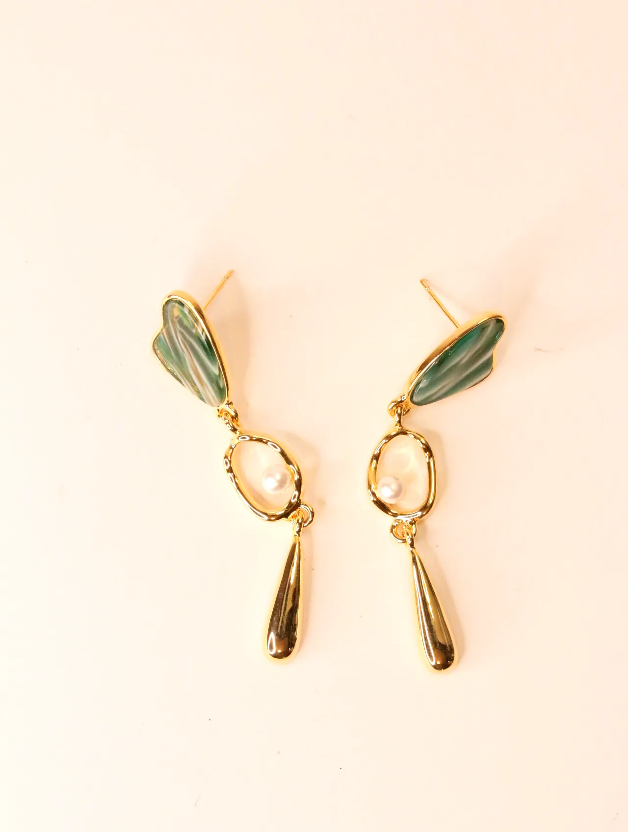 Pareja de pendientes colgantes dorados con esmalte verde y perla sobre fondo neutro — pendientes baratos, detalle · Lola y Sol (EAR-056)