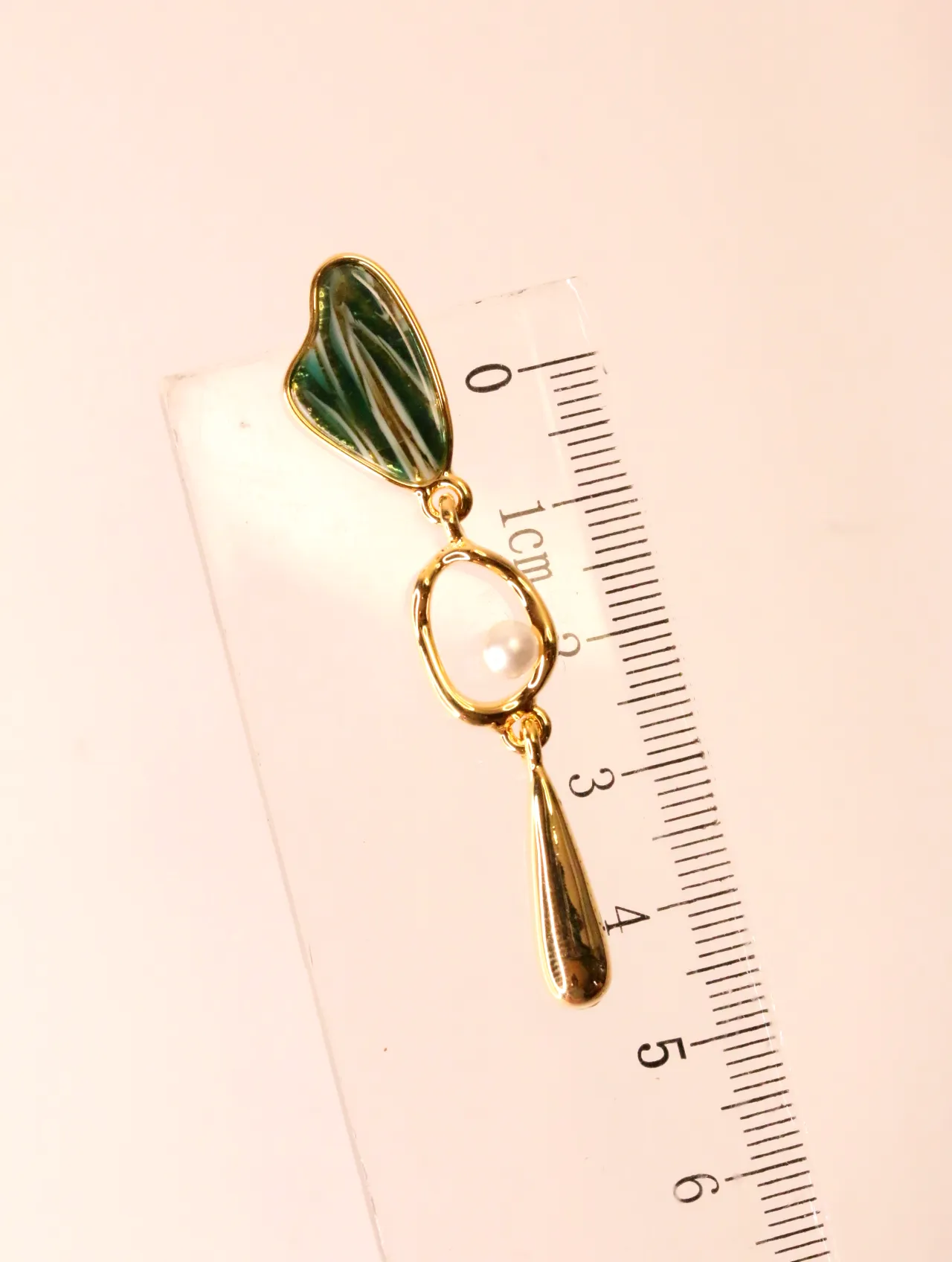 Pendiente colgante medido junto a una regla como referencia de tamaño — pendientes originales, detalle del acabado · Lola y Sol (EAR-056)