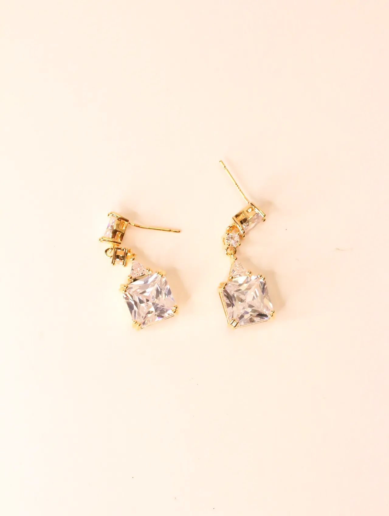 Pendientes colgantes dorados con circonitas cuadradas sobre fondo neutro — pendientes para mujer, vista principal · Lola y Sol (EAR-061)