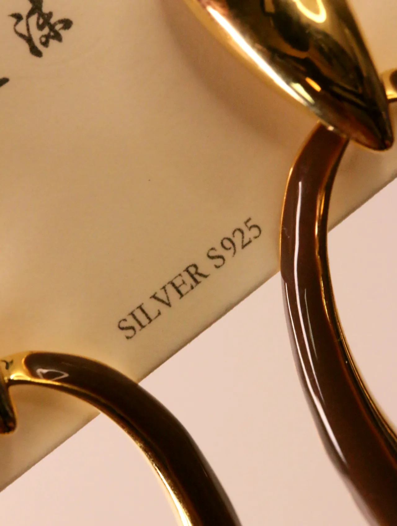 Detalle de tarjeta con indicación de pasador de plata S925 — pendientes dorados, primer plano · Lola y Sol (EAR-065)