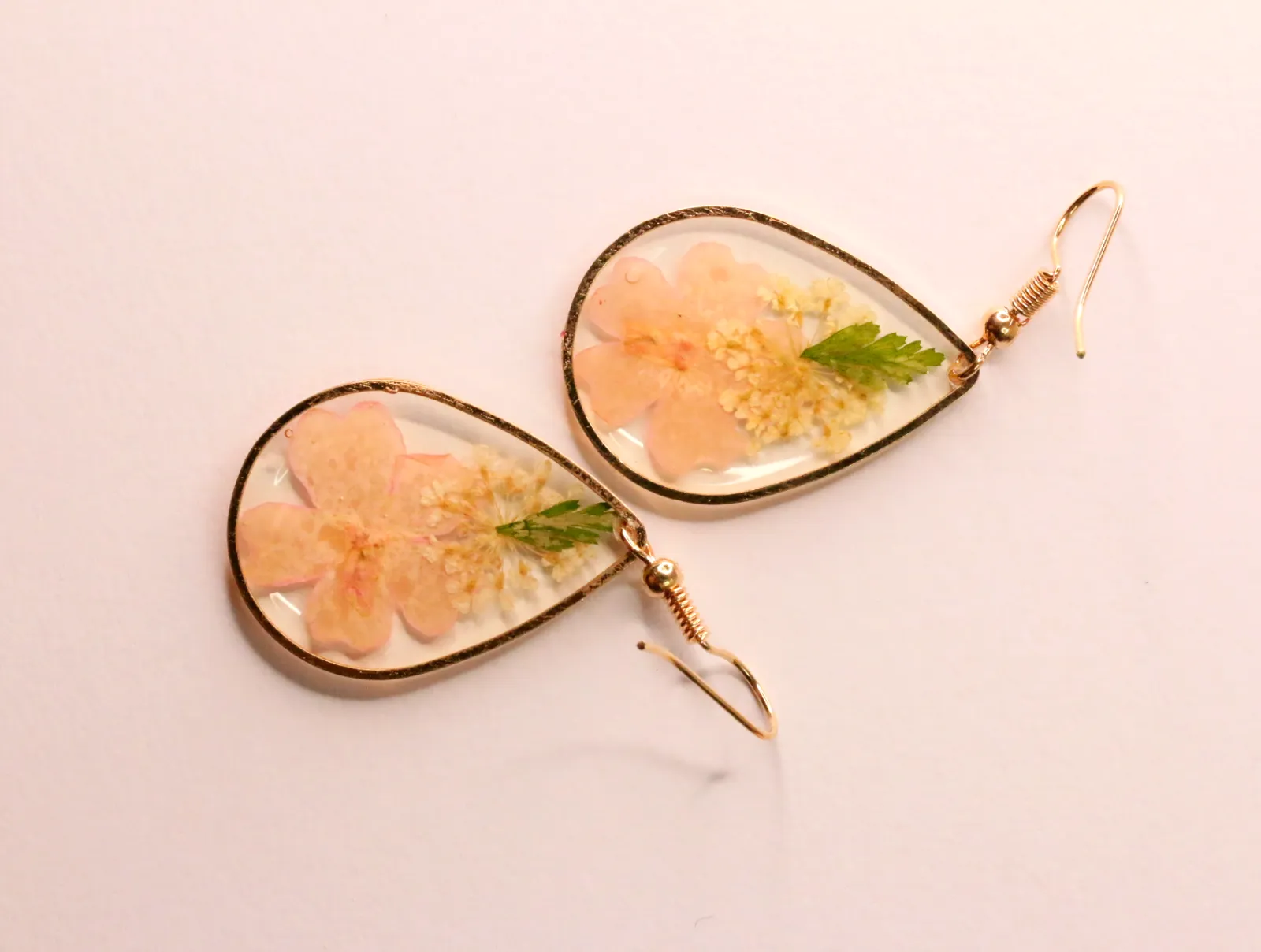 Pendientes de lágrima con flores rosas encapsuladas y enganches dorados — pendientes dorados, primer plano · Lola y Sol (EAR-070)