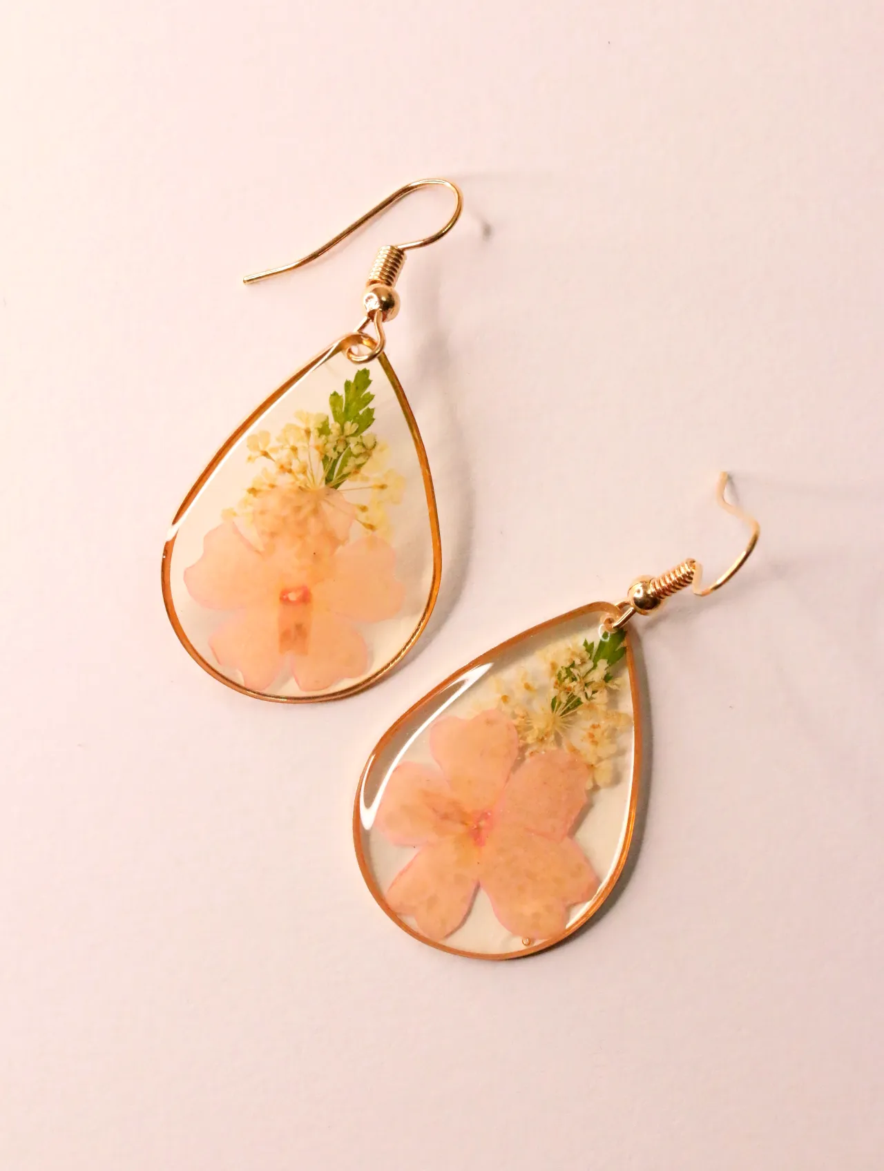 Pendientes dorados de lágrima con flores secas naturales en resina — pendientes de moda, vista lateral · Lola y Sol (EAR-070)
